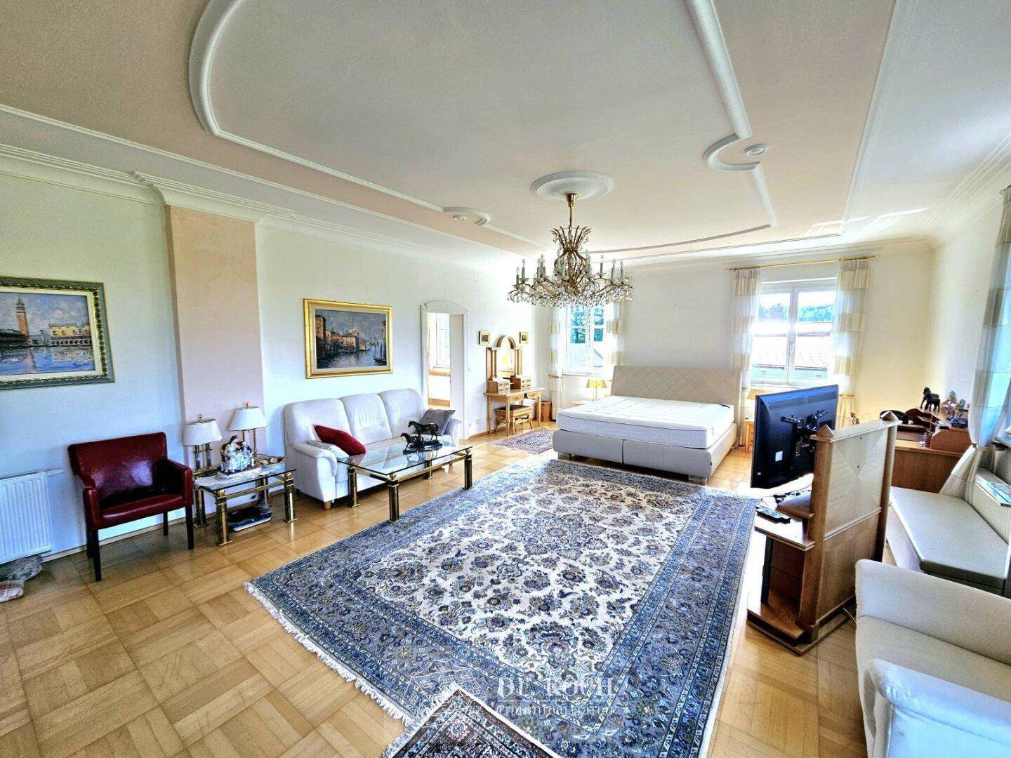 Helles Schlafzimmer mit Parkettboden, Stuckdecke und klassischer Einrichtung, bietet viel Platz.
