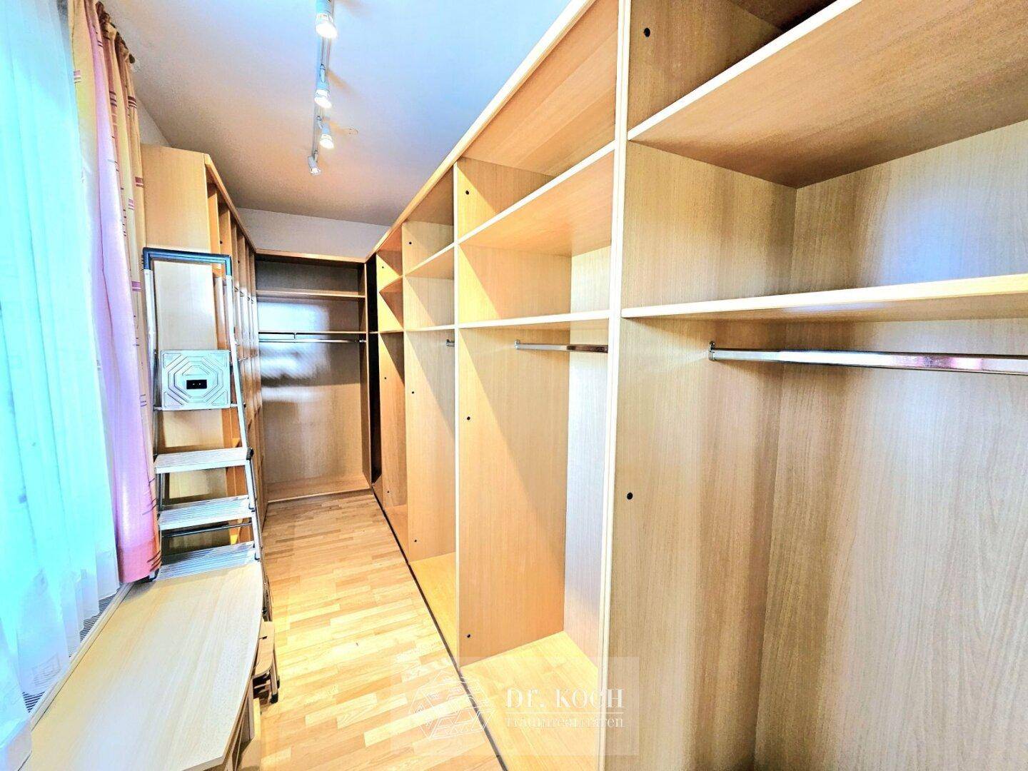 Geräumiger begehbarer Kleiderschrank mit vielen Regalen und Stauraum für Kleidung und Accessoires.