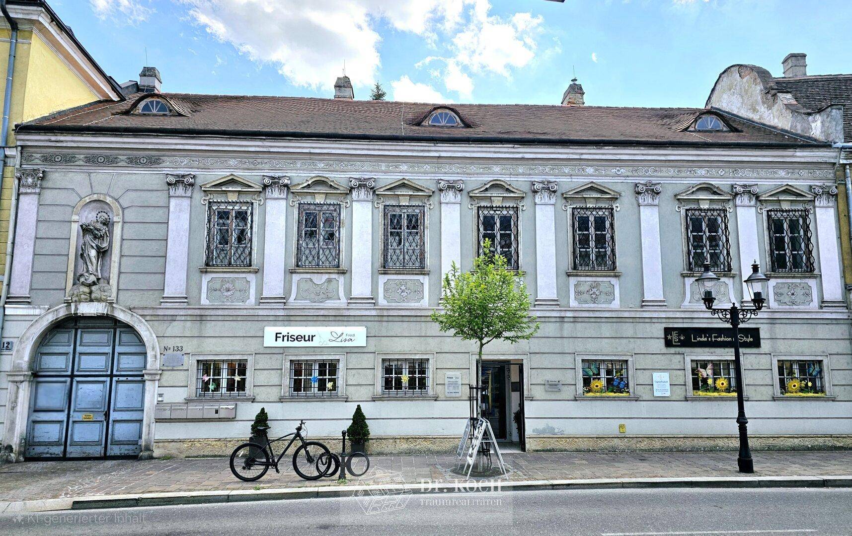 Historische Gebäudefassade mit Geschäften im Erdgeschoss und dekorativen Elementen.