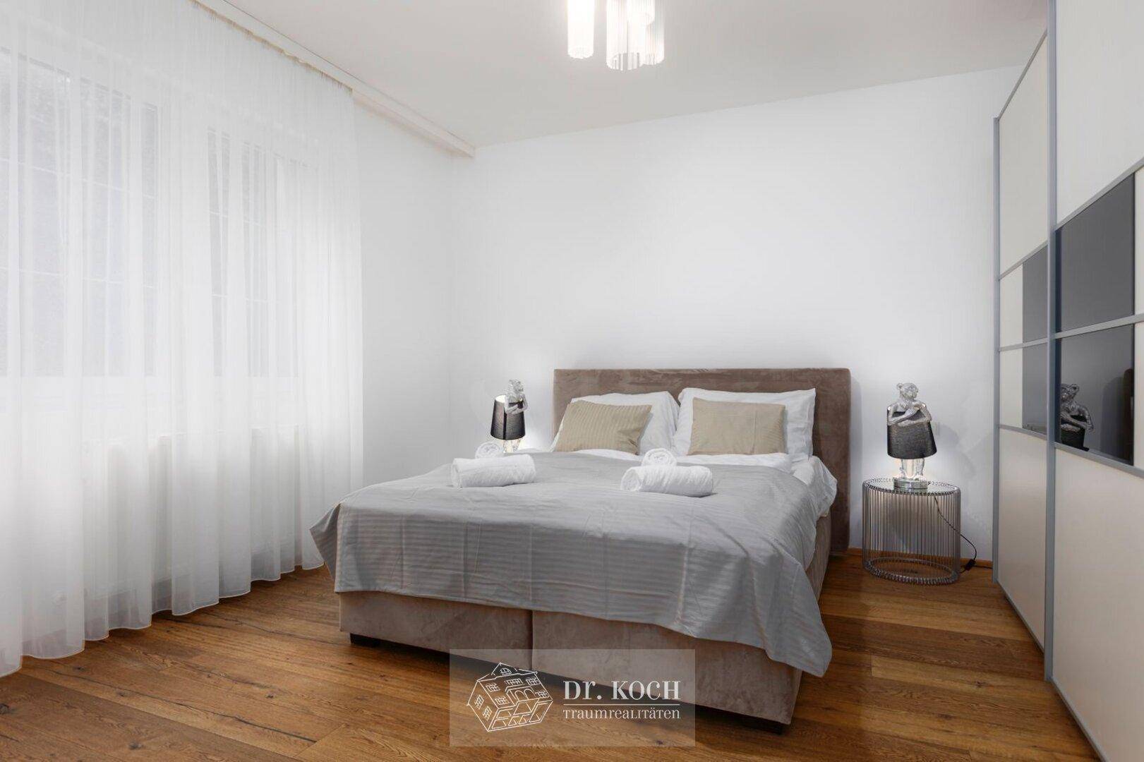 Schlafzimmer mit Holzboden, beigem Bett und integriertem Kleiderschrank für optimalen Stauraum.