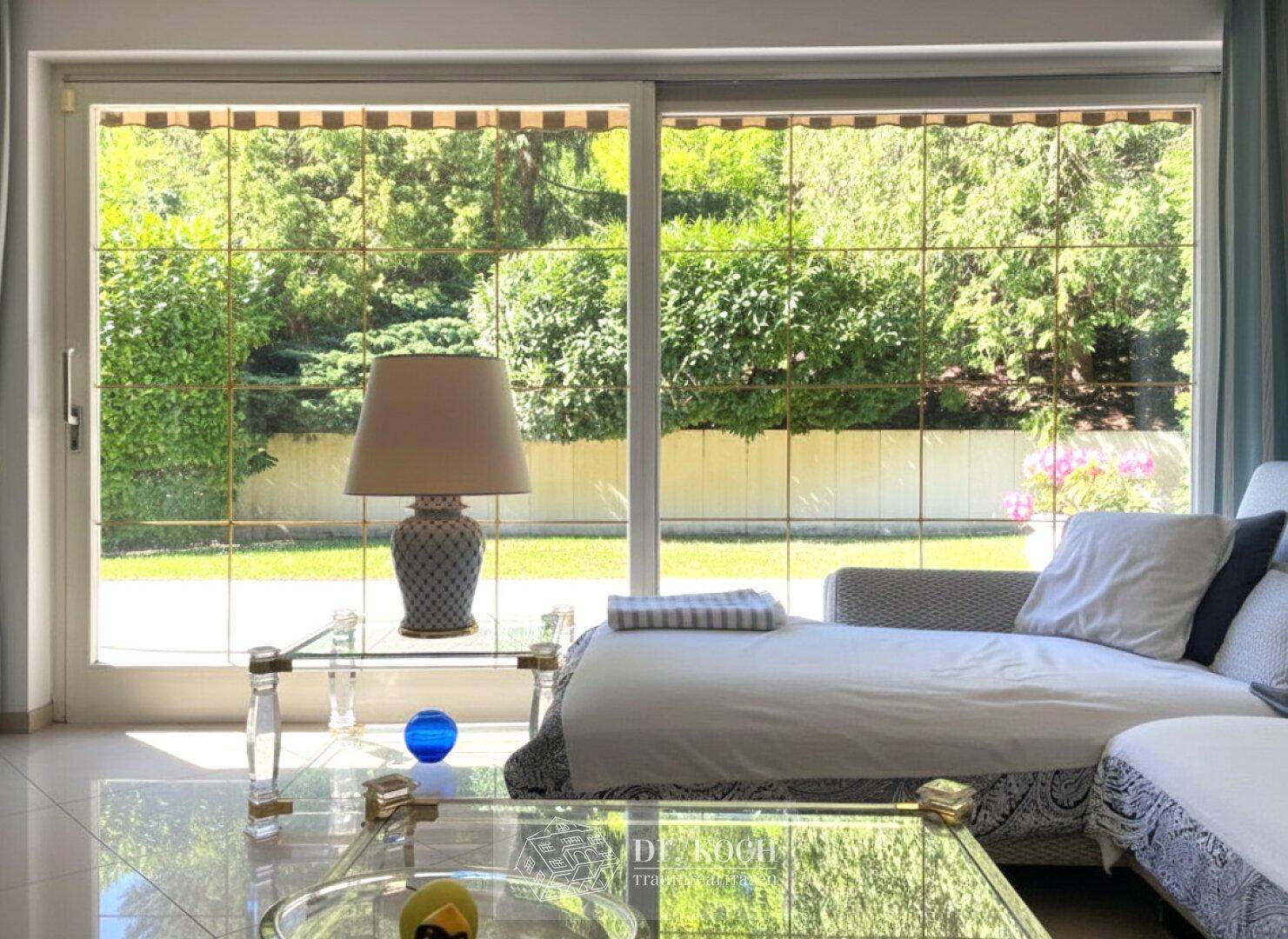 Große Fensterfront im Wohnzimmer bietet einen schönen Blick auf den gepflegten Garten.