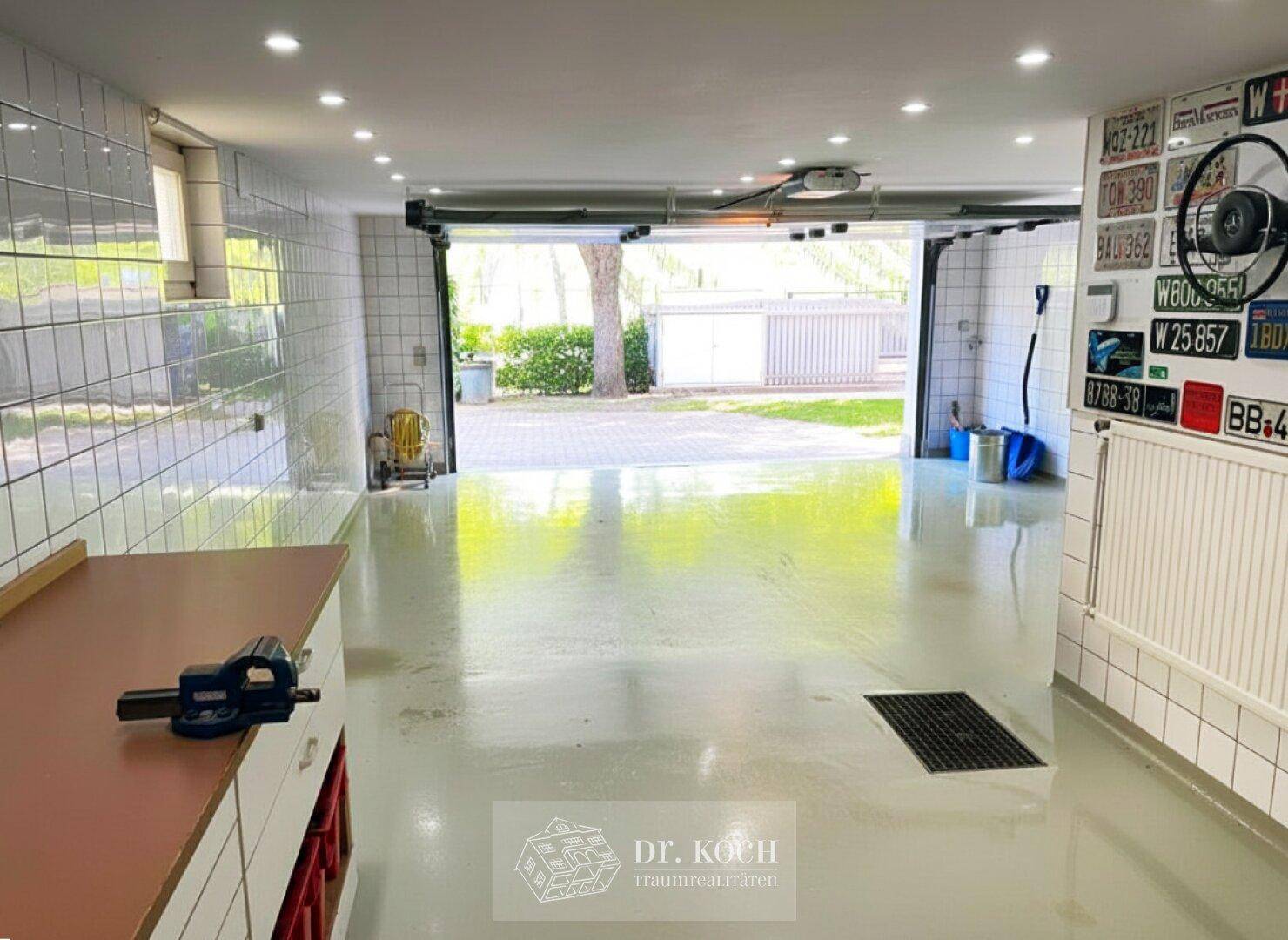 Geräumige und geflieste Garage mit viel Platz und direktem Zugang zur Einfahrt.