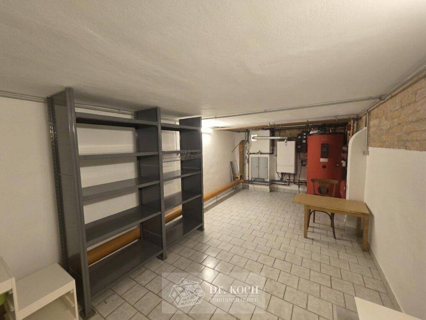 Kellerraum mit Regalen, Heizungsanlage und Fliesenboden, ideal als Lagerfläche.