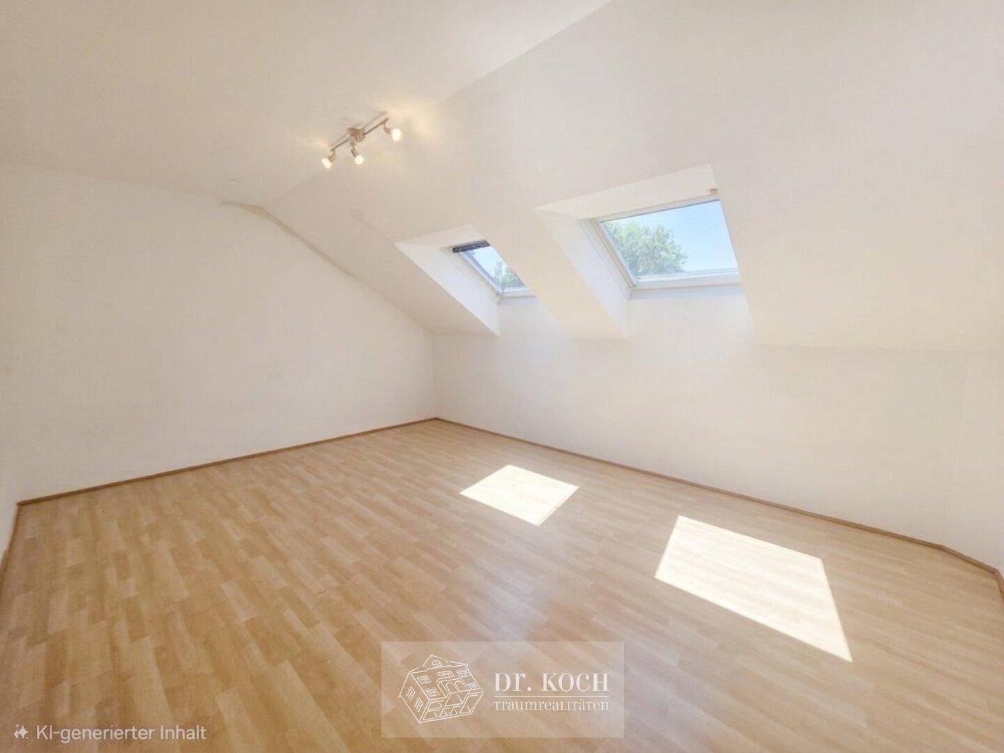 Dachzimmer mit Holzboden und zwei Dachfenstern, die den Raum mit Tageslicht durchfluten.