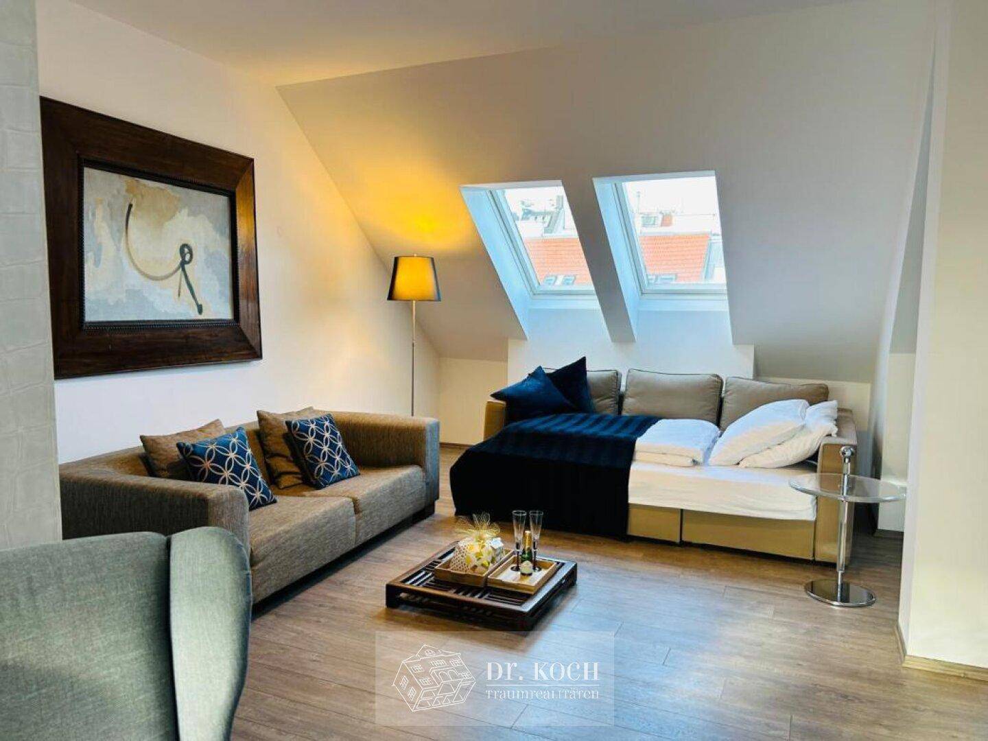 Helles Wohnzimmer im Dachgeschoss mit gemütlichen Sofas, Holzboden und Dachfenstern.