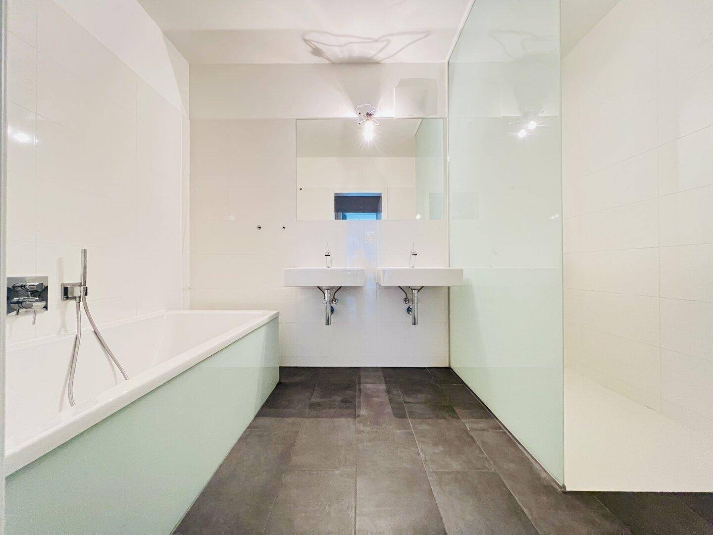Modernes Badezimmer mit Badewanne, Doppelwaschbecken und ebenerdiger Dusche.