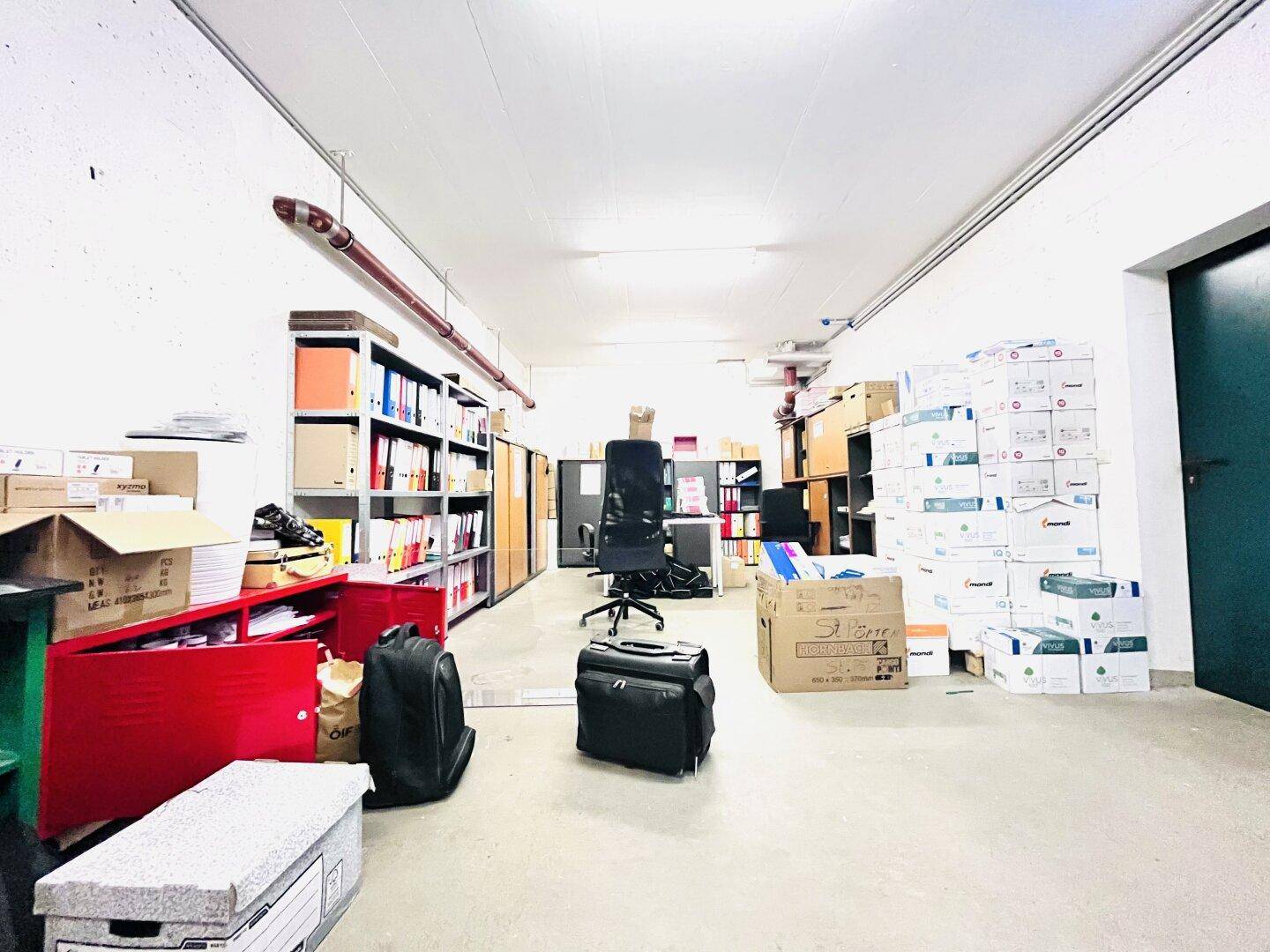 Geräumiger Lagerraum mit Regalen voller Aktenordner und Kartons, ideal für Archivierung.