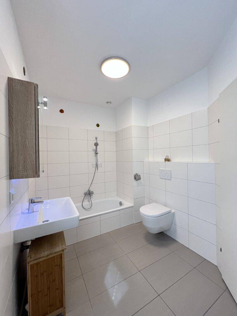 Badezimmer mit Badewanne, Wand-WC und Waschtisch, bereit für die Endmontage.