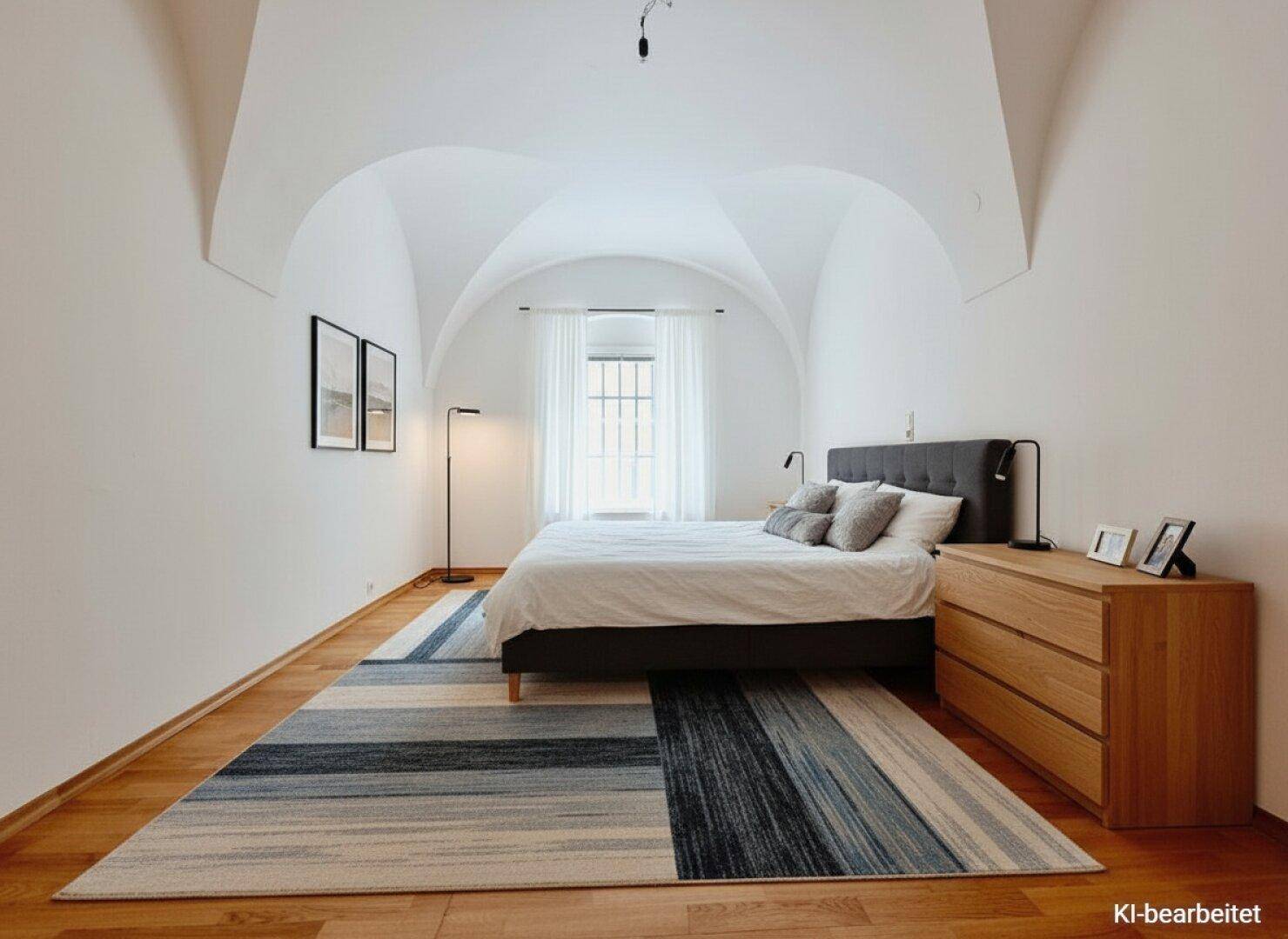 Helles Schlafzimmer mit Gewölbedecke, Holzboden und modernem Bett.