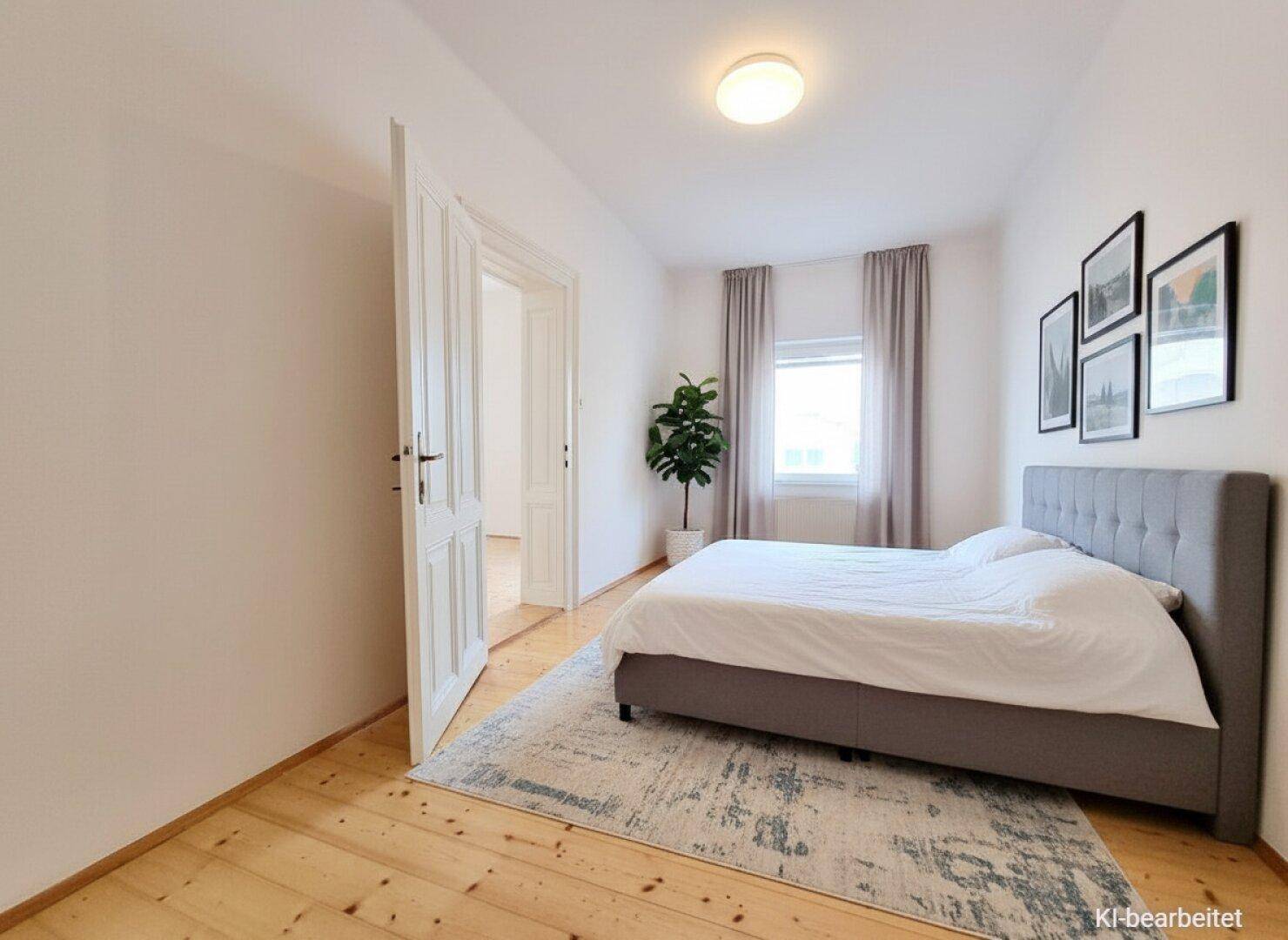 Gemütliches Schlafzimmer mit Holzdielenboden, Doppelbett und Fenster.