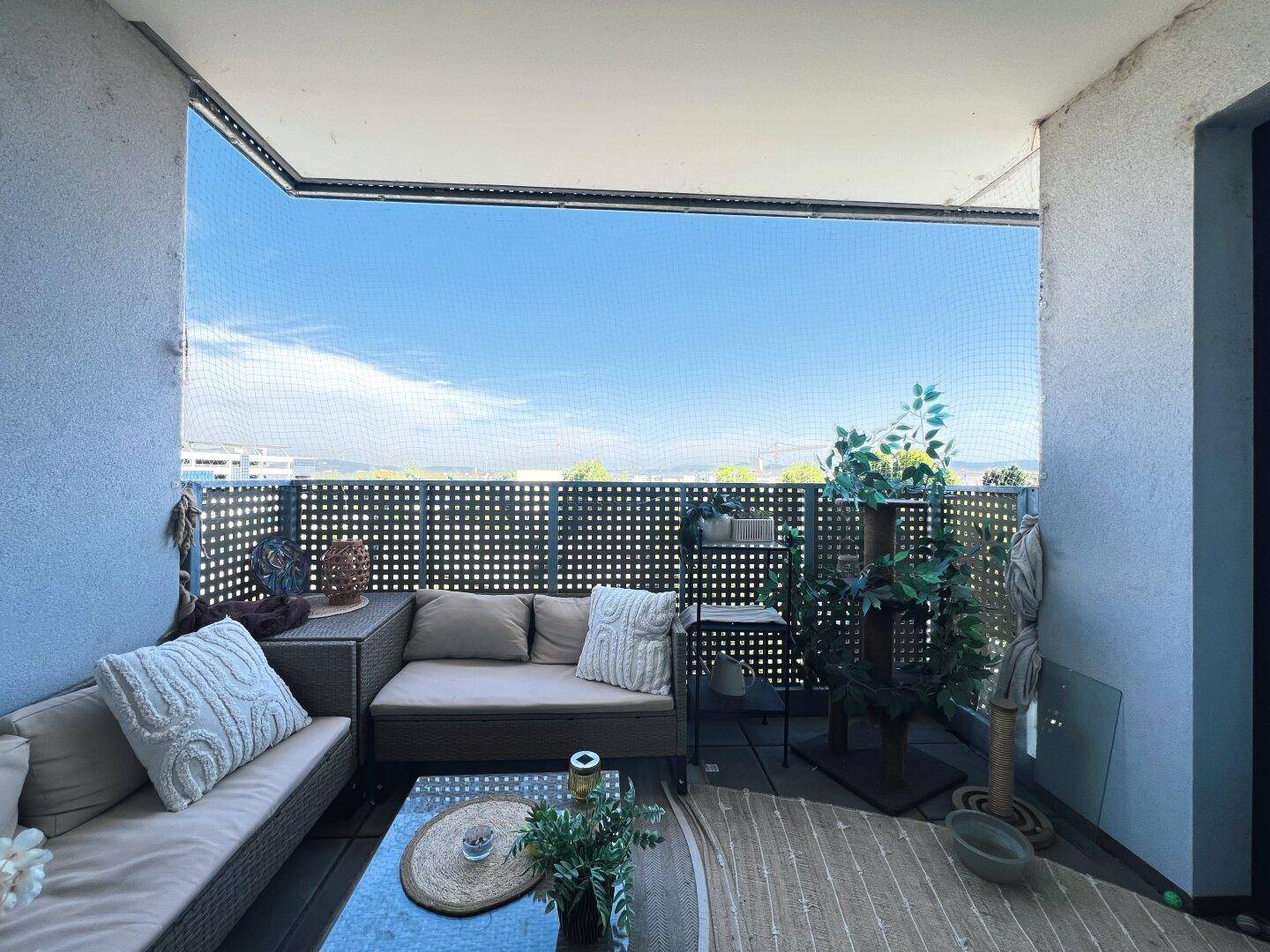 Gemütlicher Balkon mit Sitzgelegenheiten und weitem Blick in die Ferne.