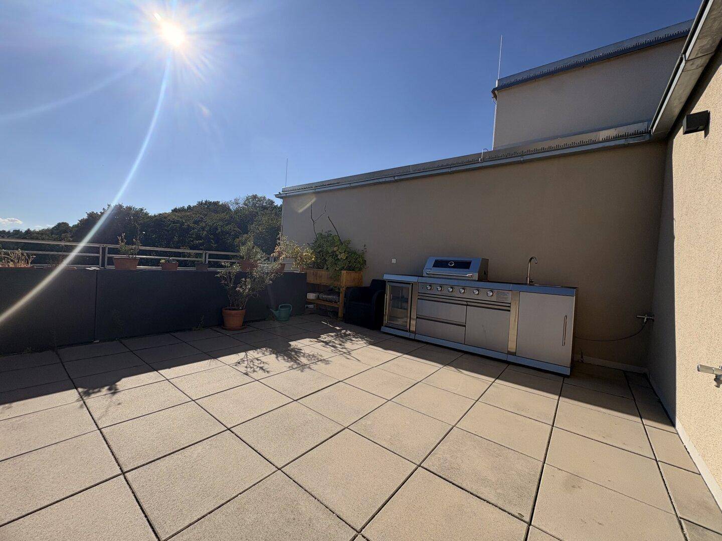 Sonnige Dachterrasse mit Außenküche und viel Platz für Entspannung und Unterhaltung.
