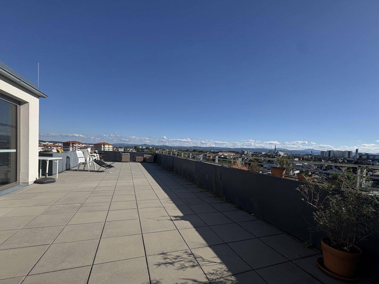 Weitläufige Dachterrasse mit Panoramablick über die Stadt und die umliegende Landschaft.