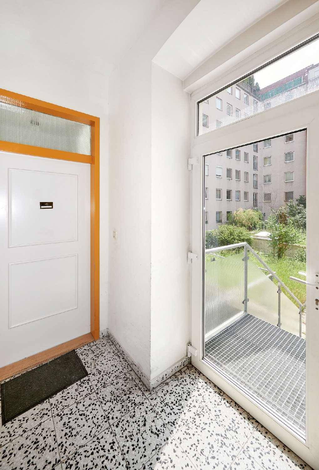 Kleiner Balkon mit Blick auf umliegende Gebäude und Grünflächen, ideal für frische Luft.