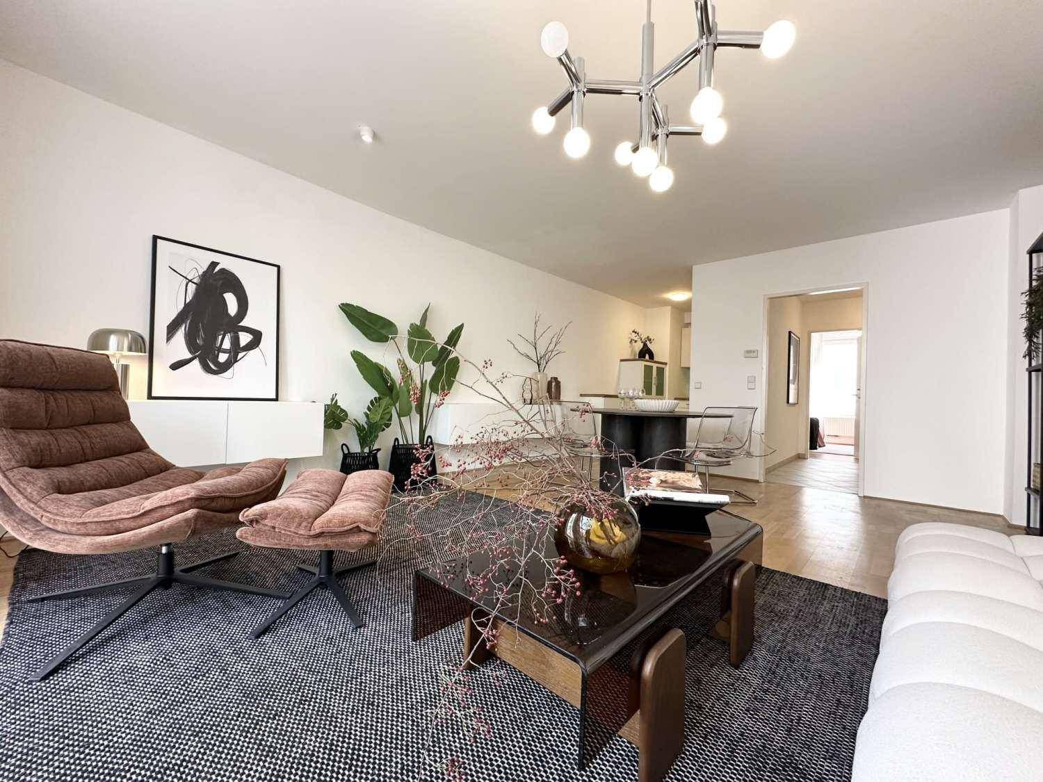 Geräumiges Wohnzimmer mit stilvollen Möbeln, Holzboden und moderner Beleuchtung.