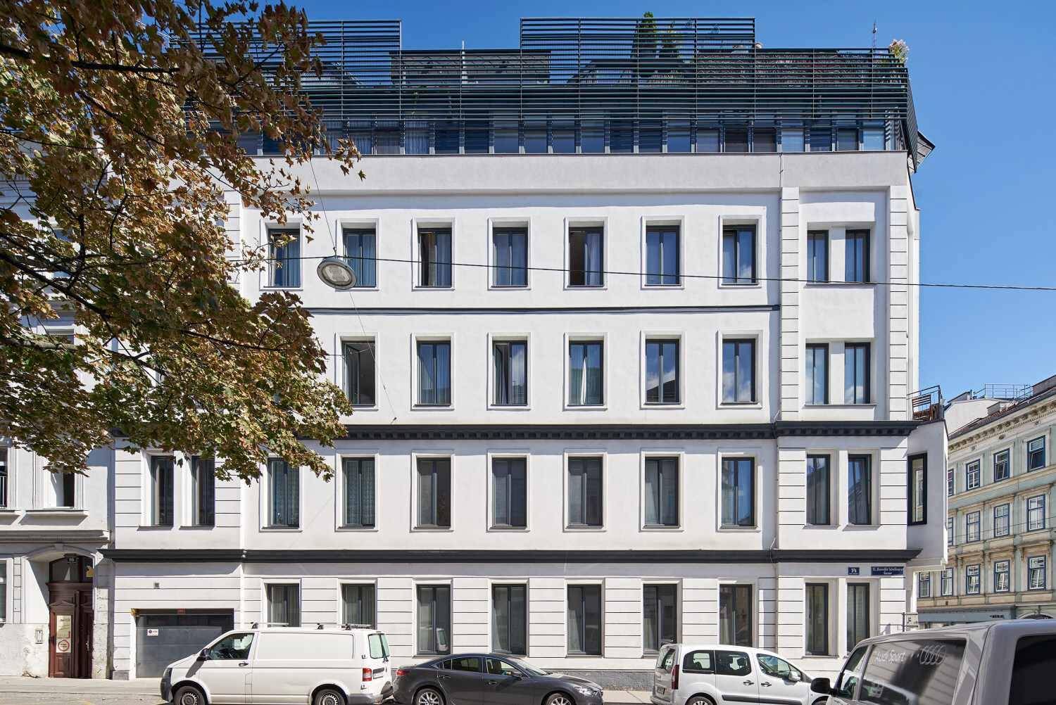Ansicht der modernen Gebäudefassade mit vielen Fenstern und Dachaufbau.