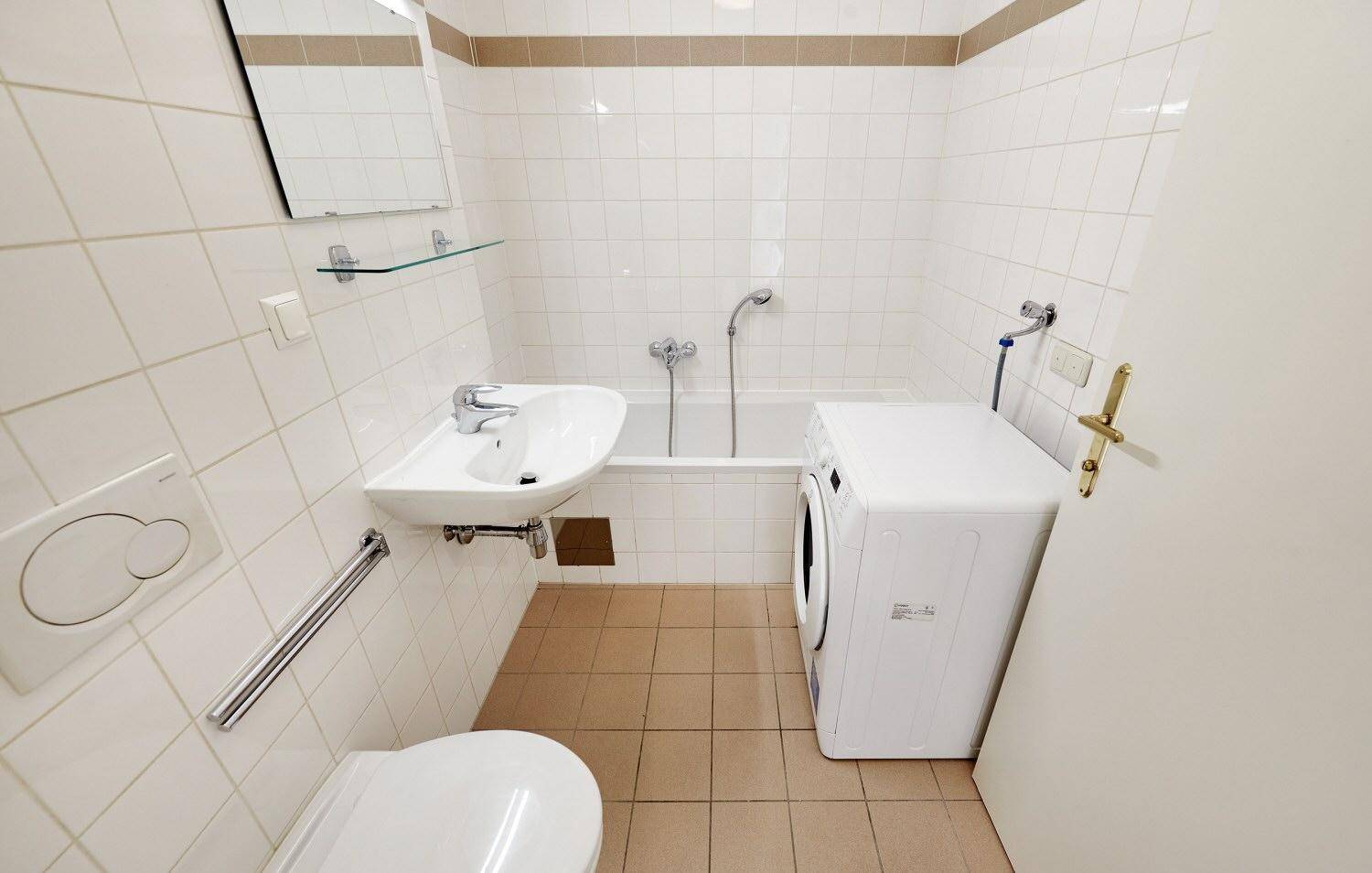 Übersicht des Badezimmers mit WC, Waschbecken, Badewanne und Waschmaschine, in gutem Zustand.