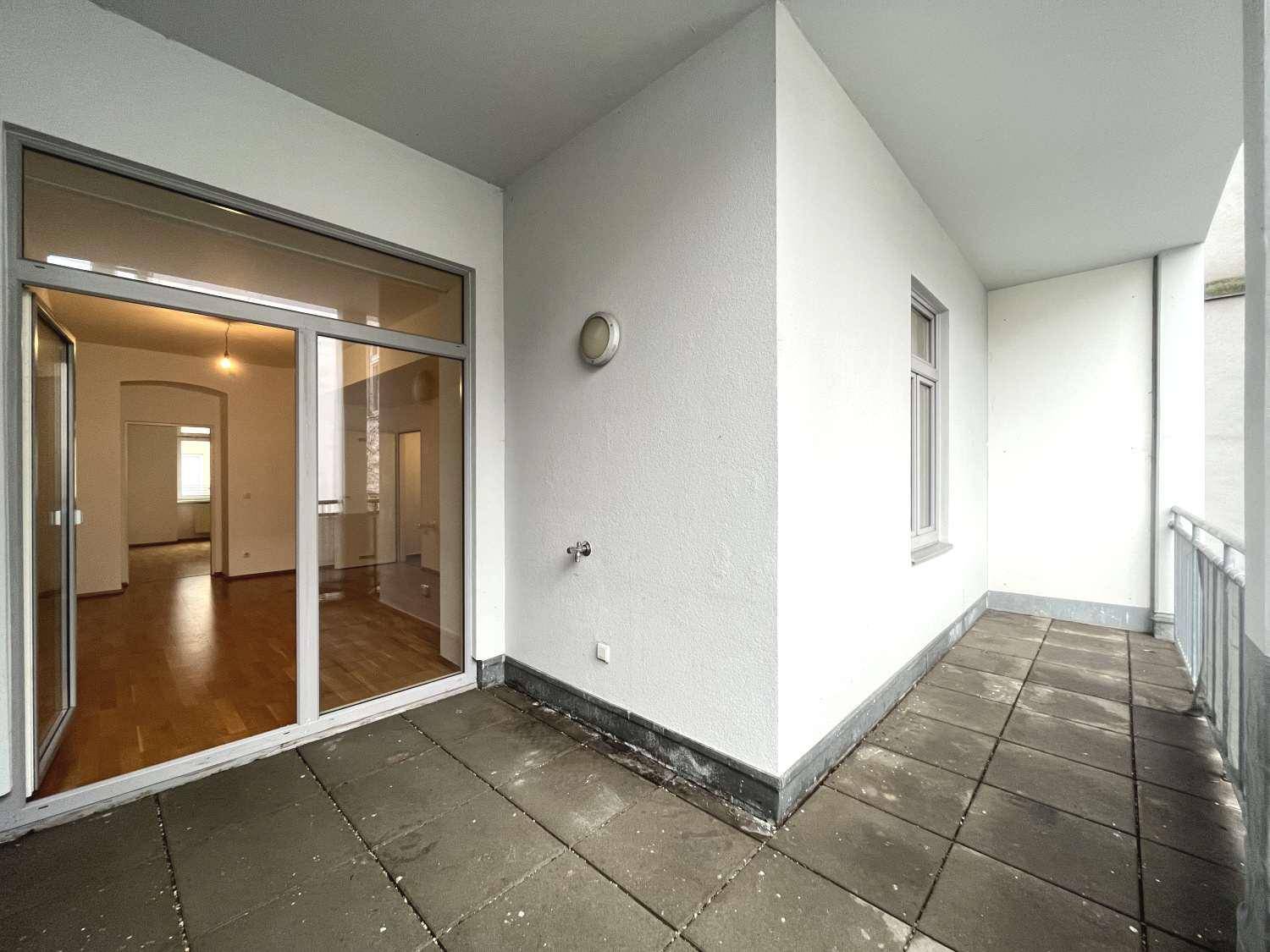 Geräumiger Balkon mit Fliesenboden und Blick auf die umliegenden Gebäude.