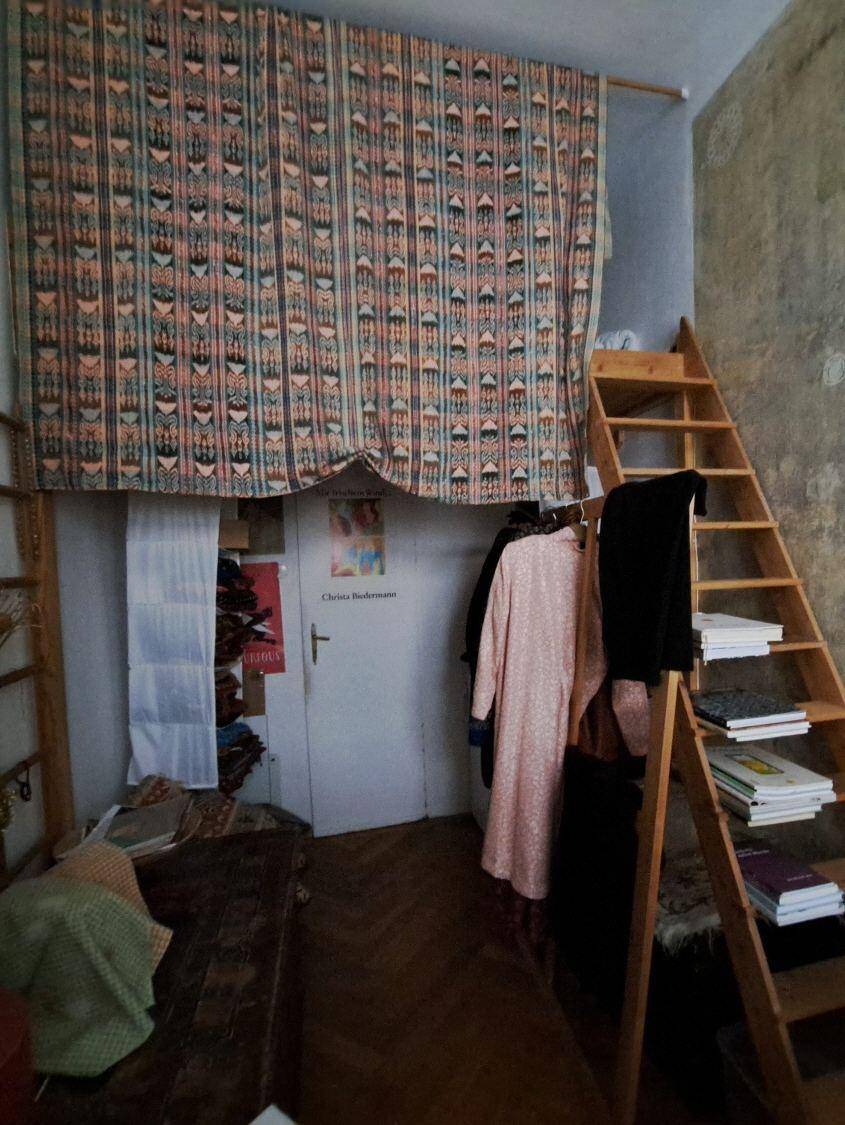 Zimmer mit Hochbett-Struktur, Holzleiter und Stauraum, ideal für kleine Räume und effiziente Nutzung.