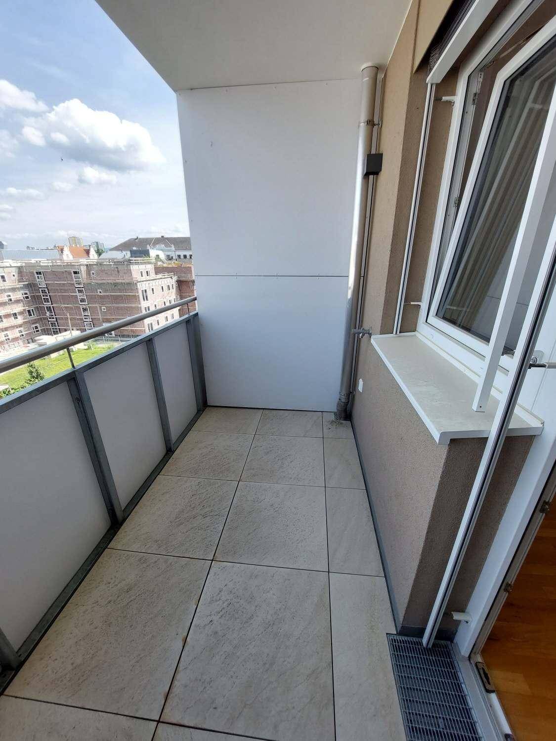 Balkon mit Fliesenboden und Blick auf die umliegende Bebauung.