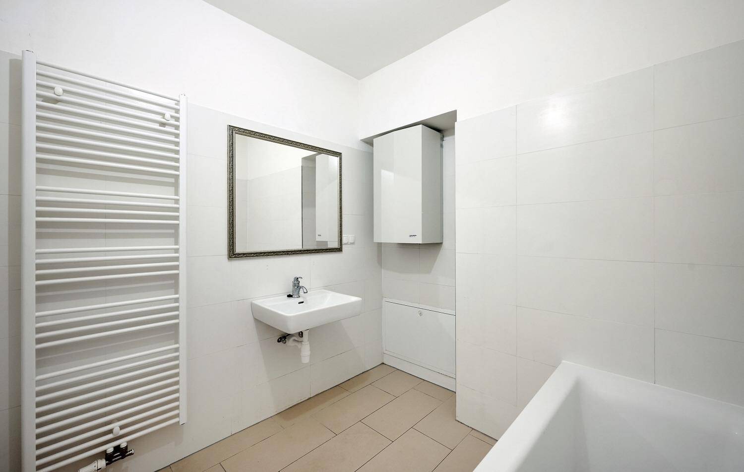 Modernes Badezimmer mit Waschbecken, Spiegel, Badewanne und beheiztem Handtuchhalter.