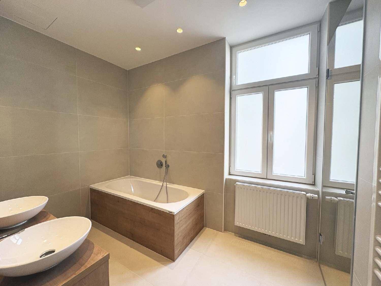 Modernes Badezimmer mit zwei Aufsatzwaschbecken, Badewanne und großen Fliesen, sehr gepflegt.