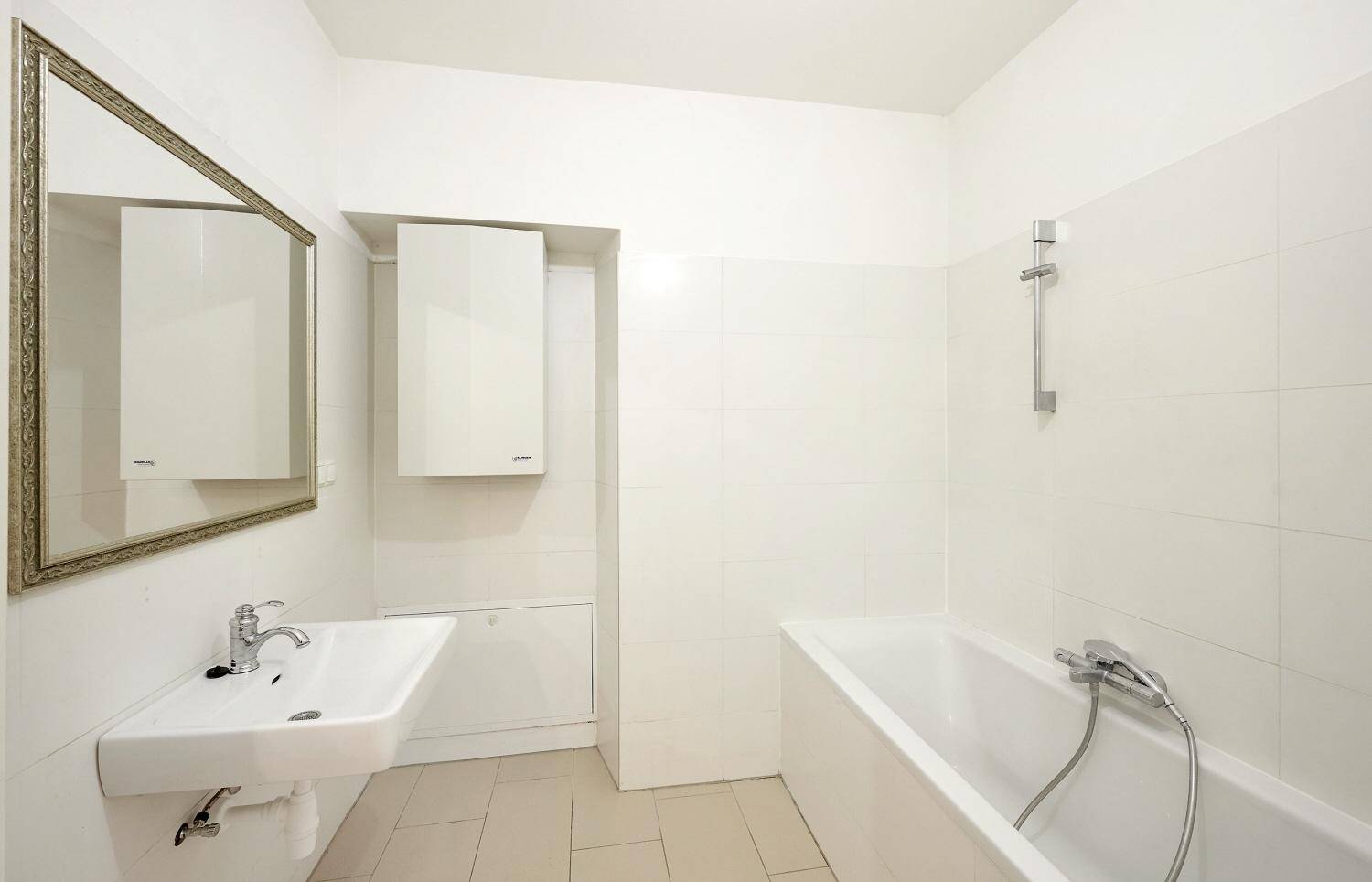 Helles Badezimmer mit Badewanne, Waschbecken und Spiegel, in gutem Zustand.
