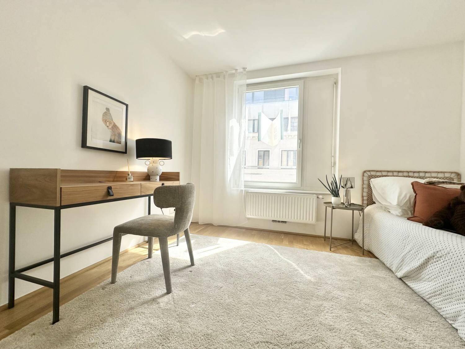 Ruhiges Schlafzimmer mit Schreibtisch, Einzelbett und hellem Ambiente.