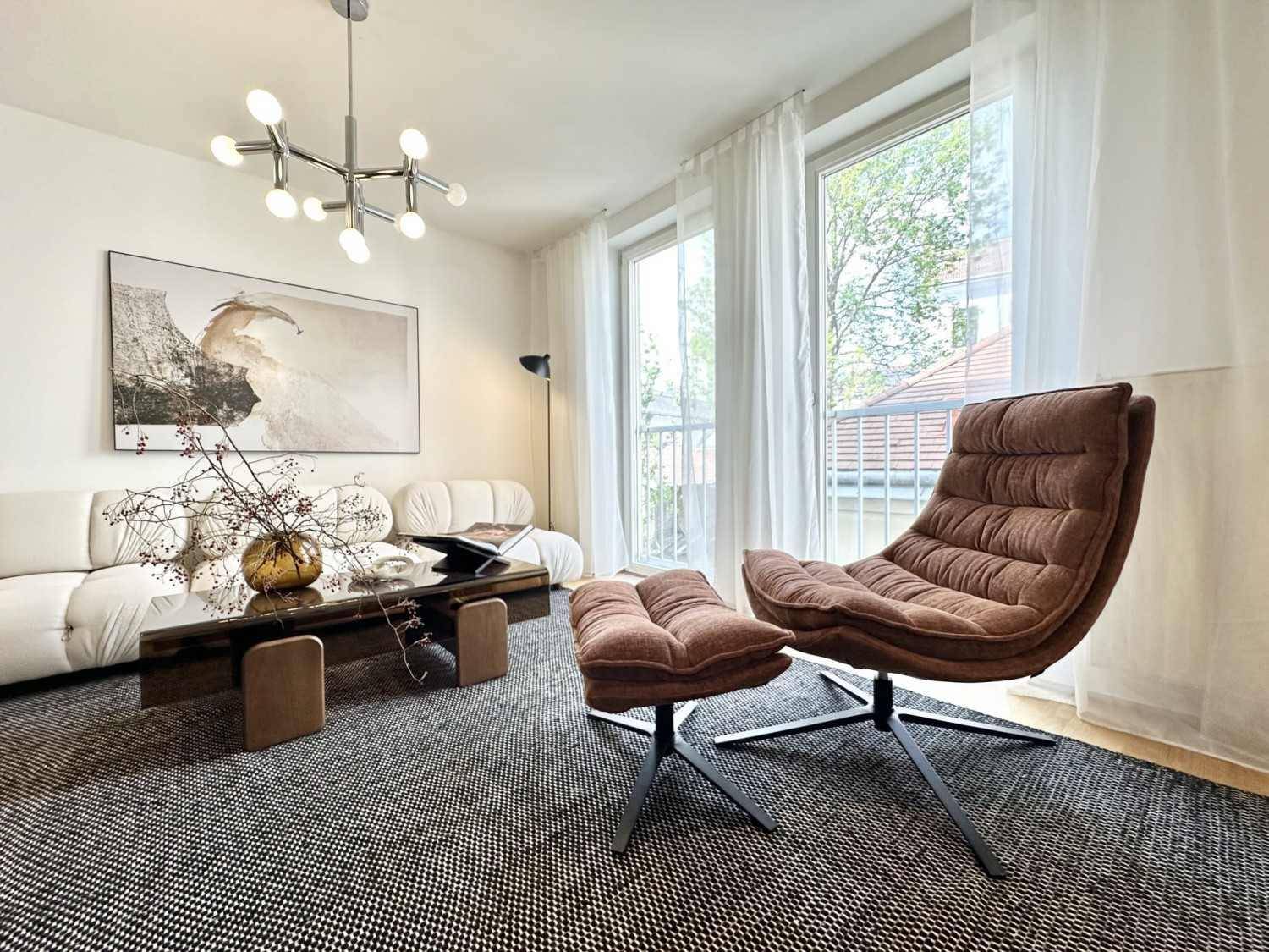 Modern eingerichtetes Wohnzimmer mit bequemen Sitzgelegenheiten und viel Tageslicht.