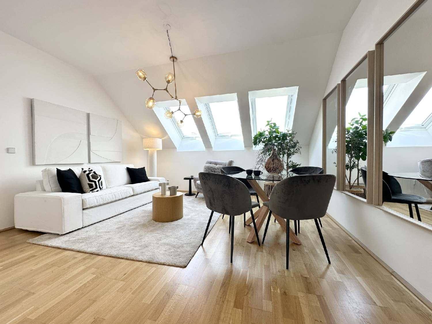 Geräumiges Wohn- und Esszimmer mit modernen Möbeln, Holzboden und viel Tageslicht durch Dachfenster.