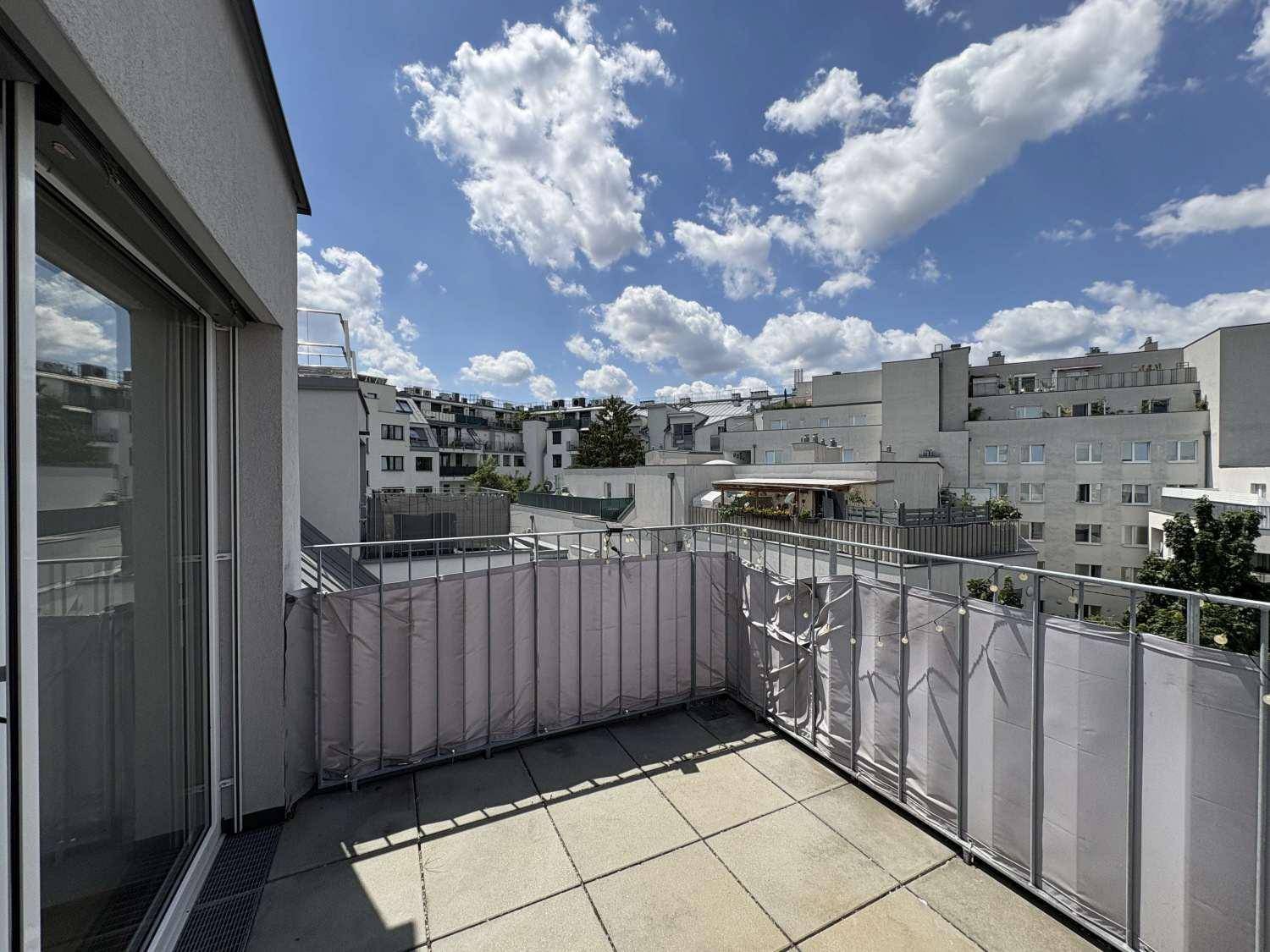 Geräumige Dachterrasse mit Fliesenboden und weitem Blick über die städtische Umgebung.