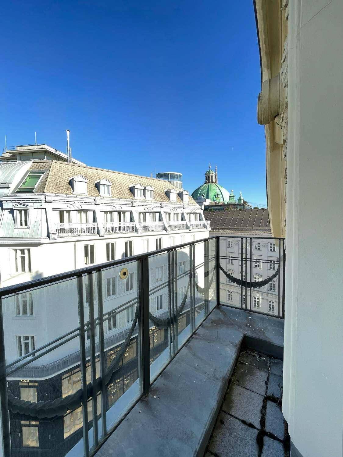 Kleiner Balkon mit schmiedeeisernem Geländer und Blick auf die historischen Dächer der Stadt.