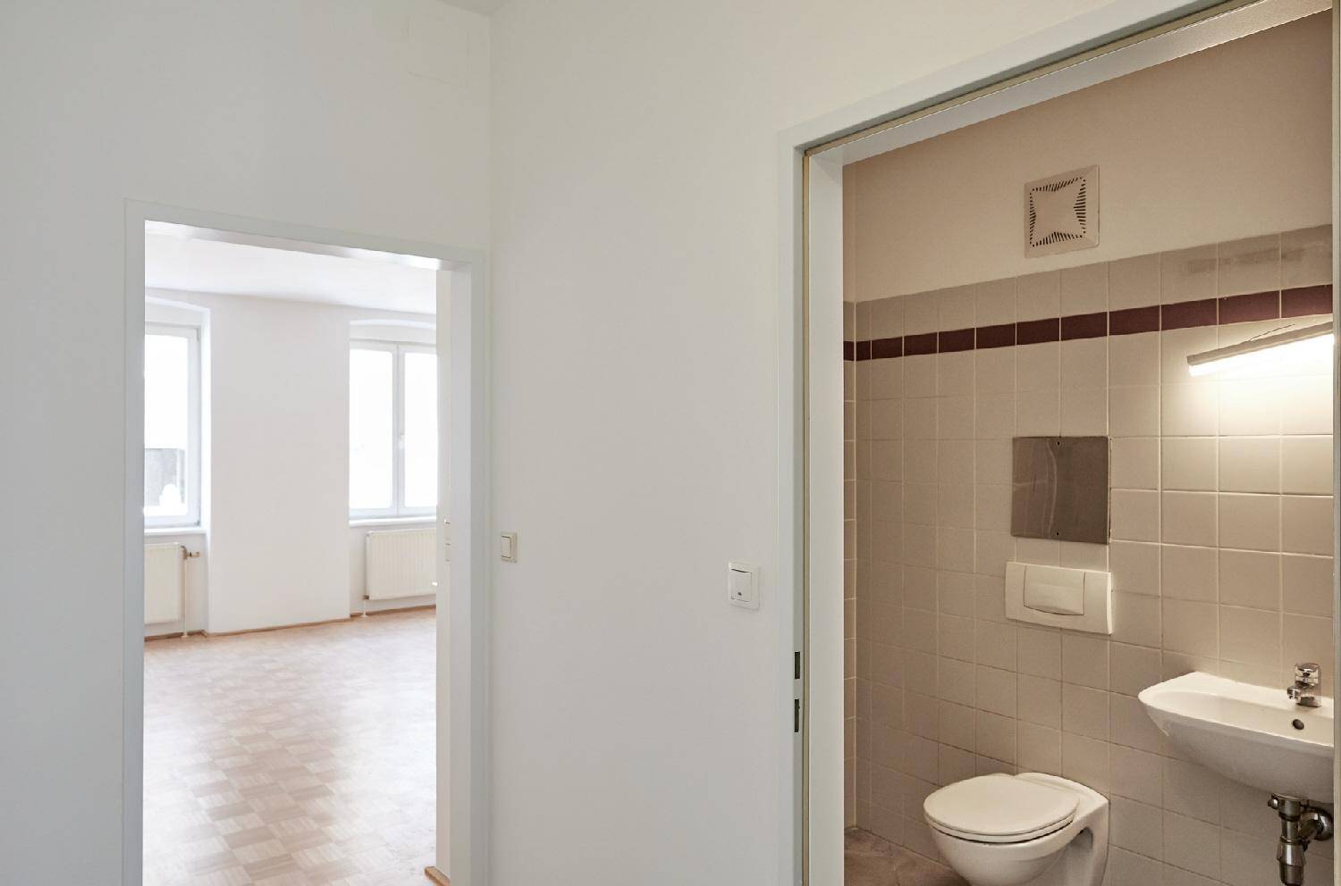 Kleines Gäste-WC mit Waschbecken und Toilette, vom Flur aus zugänglich.