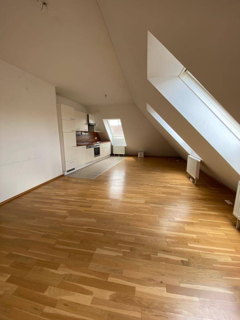 Heller Wohnbereich mit offener Küche, Dachschrägen und großen Dachfenstern für viel Licht.