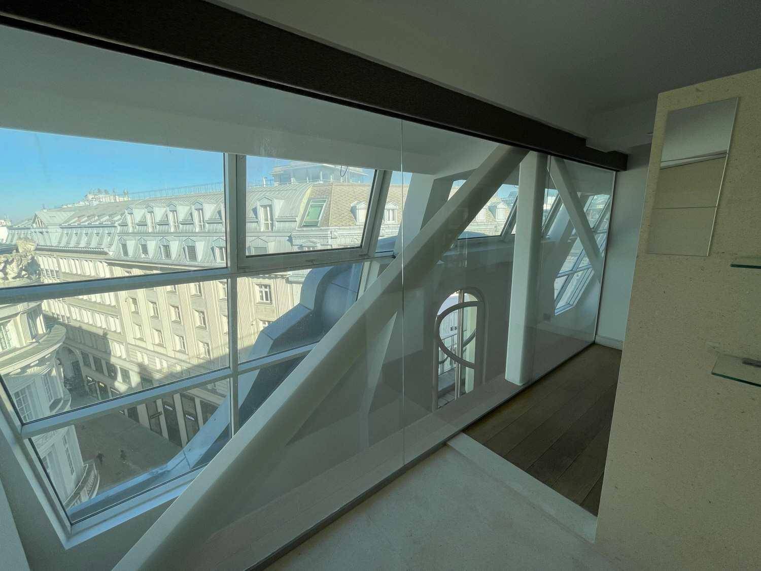 Heller Wohnbereich mit beeindruckenden Glasfronten und strukturellen Elementen, die einen weiten Stadtblick bieten.