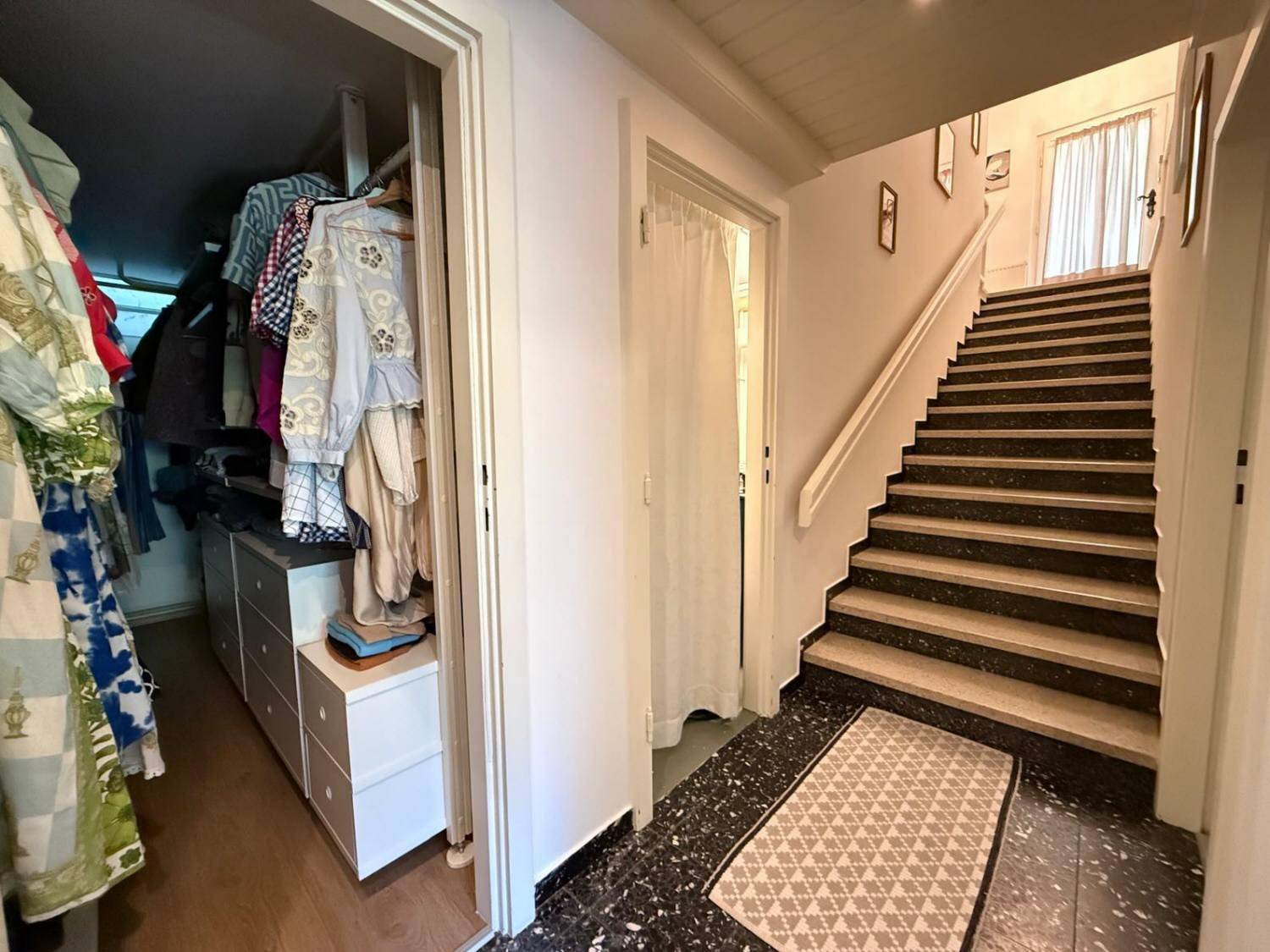 Flur mit Zugang zu einem begehbaren Kleiderschrank und einer Treppe ins Obergeschoss.