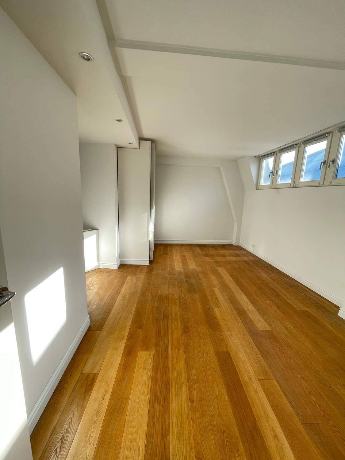 Helles Zimmer mit Holzboden und Dachschrägen, bietet eine gemütliche Atmosphäre und vielseitige Nutzungsmöglichkeiten.