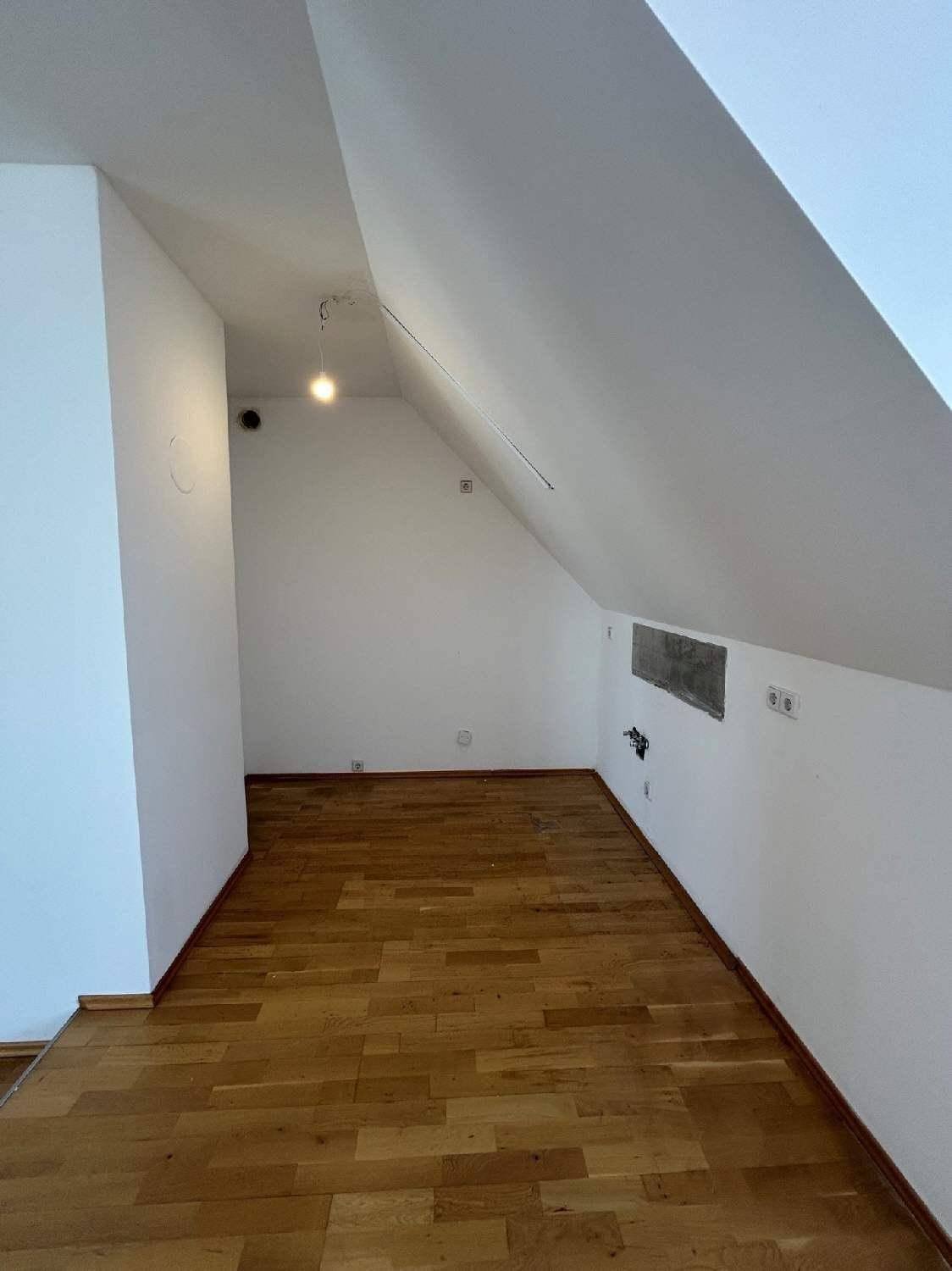 Weiterer Raum im Dachgeschoss mit Holzboden und schrägen Wänden, bietet flexible Nutzungsmöglichkeiten.
