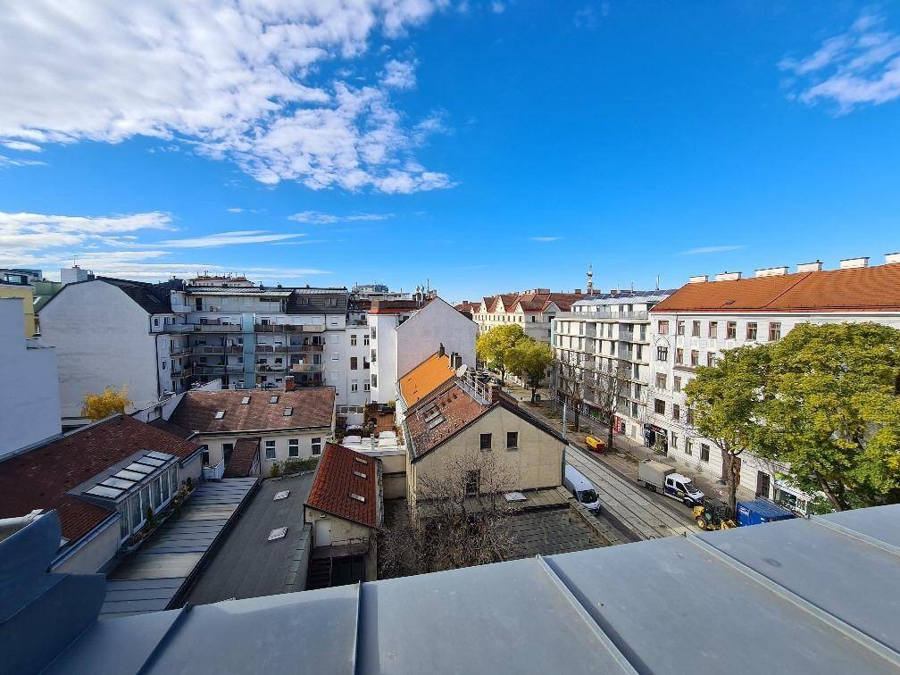 Panoramablick über die Dächer der Stadt mit blauer Himmel und umliegenden Gebäuden.