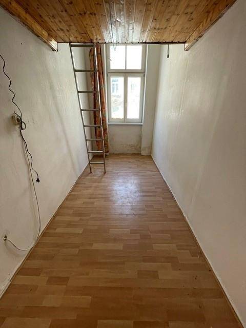 Schmaler Raum mit Holzdecke, Leiter zur Schlafebene und Fenster für Tageslicht.