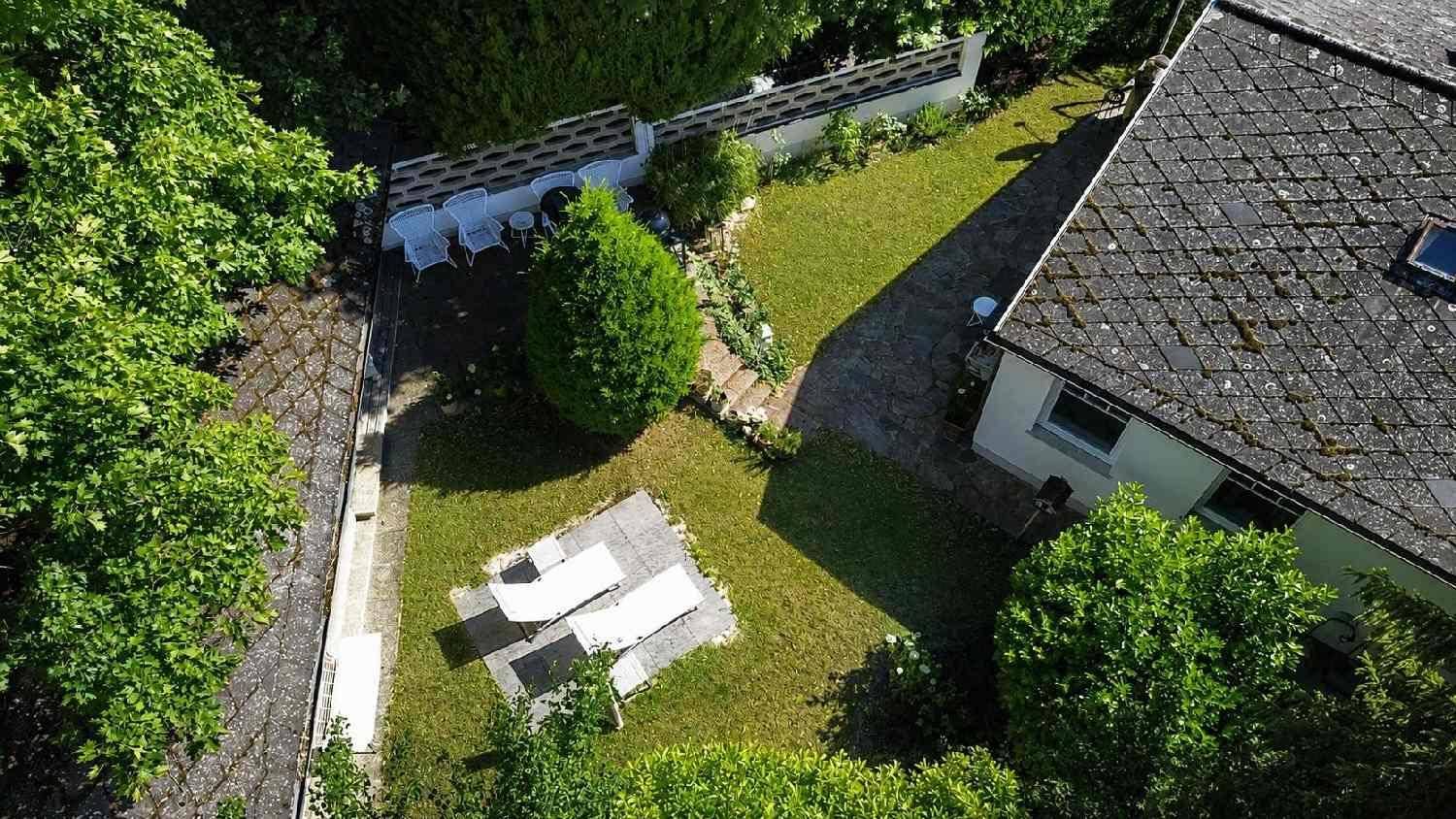 Gartenbereich mit Rasenfläche, Sonnenliegen und einer Terrasse für entspannte Stunden im Freien.
