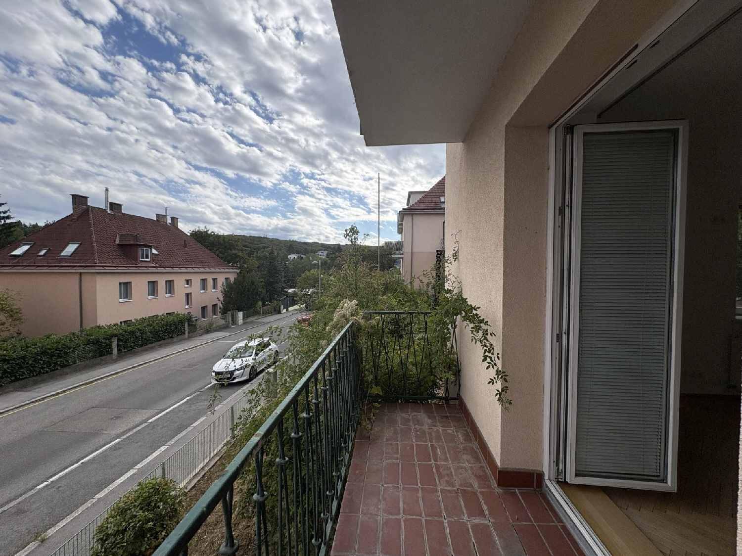 Balkon mit Blick auf die Straße und umliegende Gebäude, ideal für Entspannung im Freien.