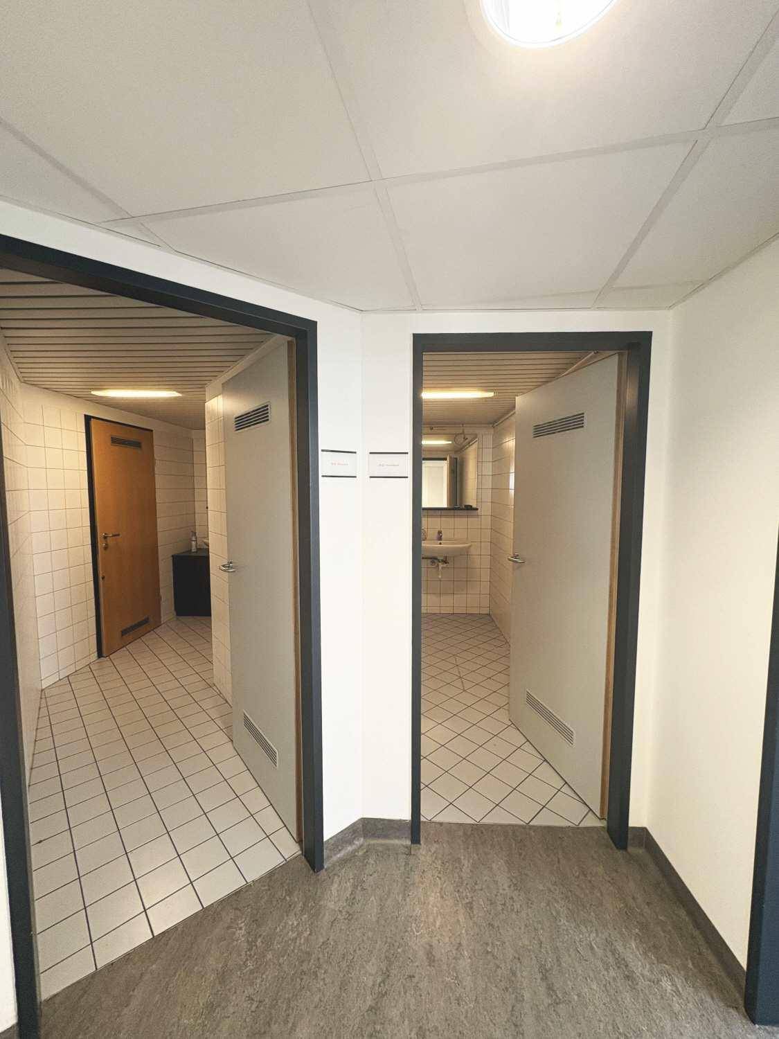 Zwei separate Eingänge zu gefliesten Räumen, wahrscheinlich Badezimmer oder Toiletten.