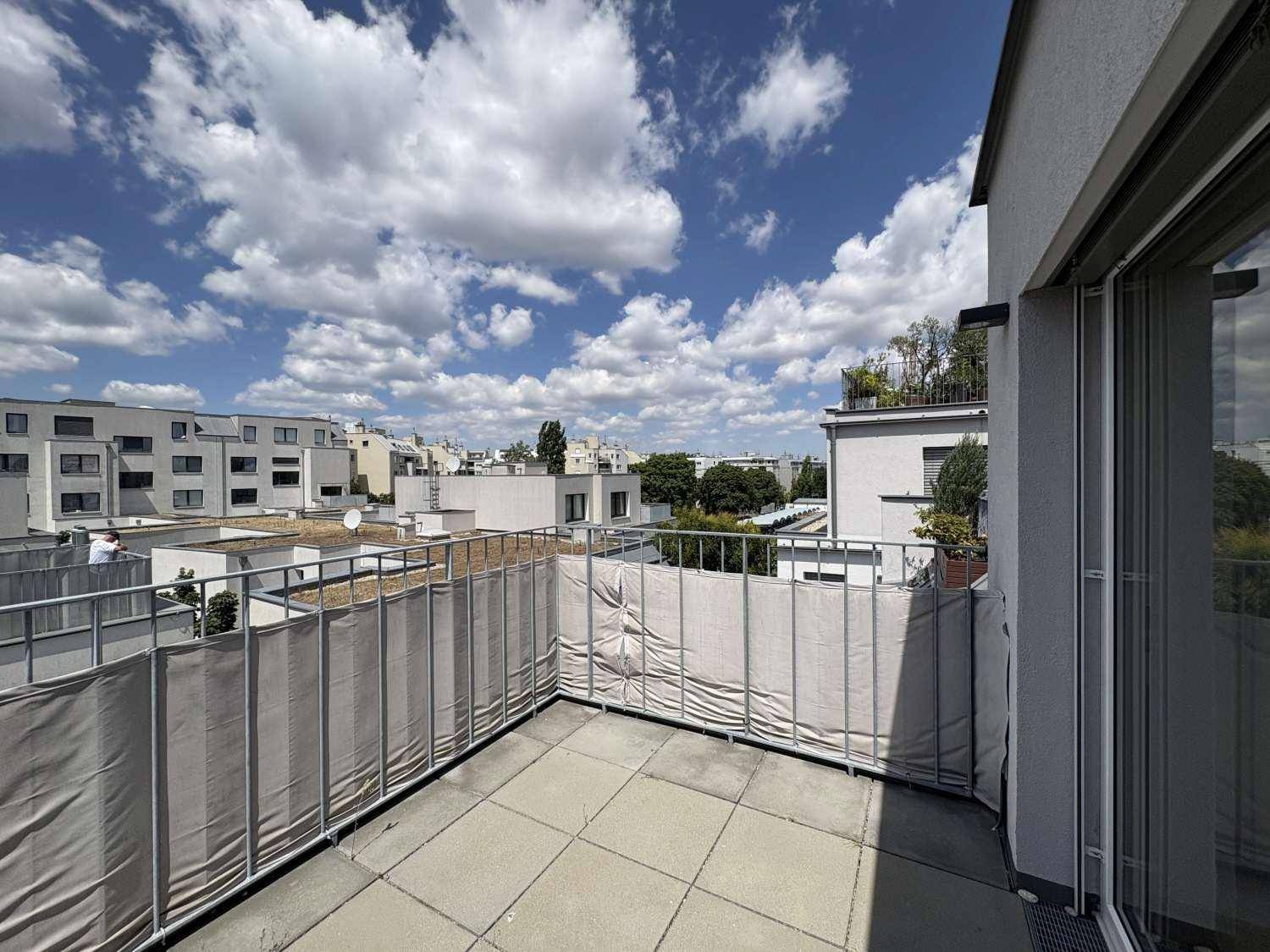 Sonniger Außenbereich auf der Terrasse mit Blick auf die Dächer der Stadt.