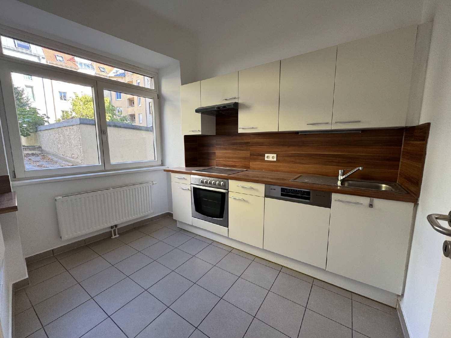 Funktionale Küche mit hellen Schränken, Holzoptik-Arbeitsplatte und Fliesenboden, bereit zur Nutzung.