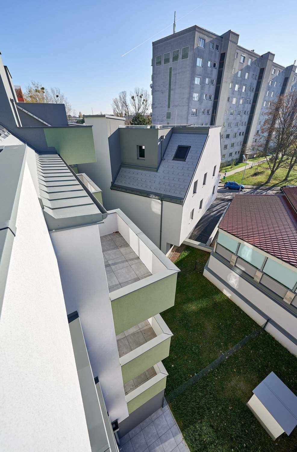 Dachlandschaft und Balkone eines modernen Wohnkomplexes aus der Vogelperspektive.