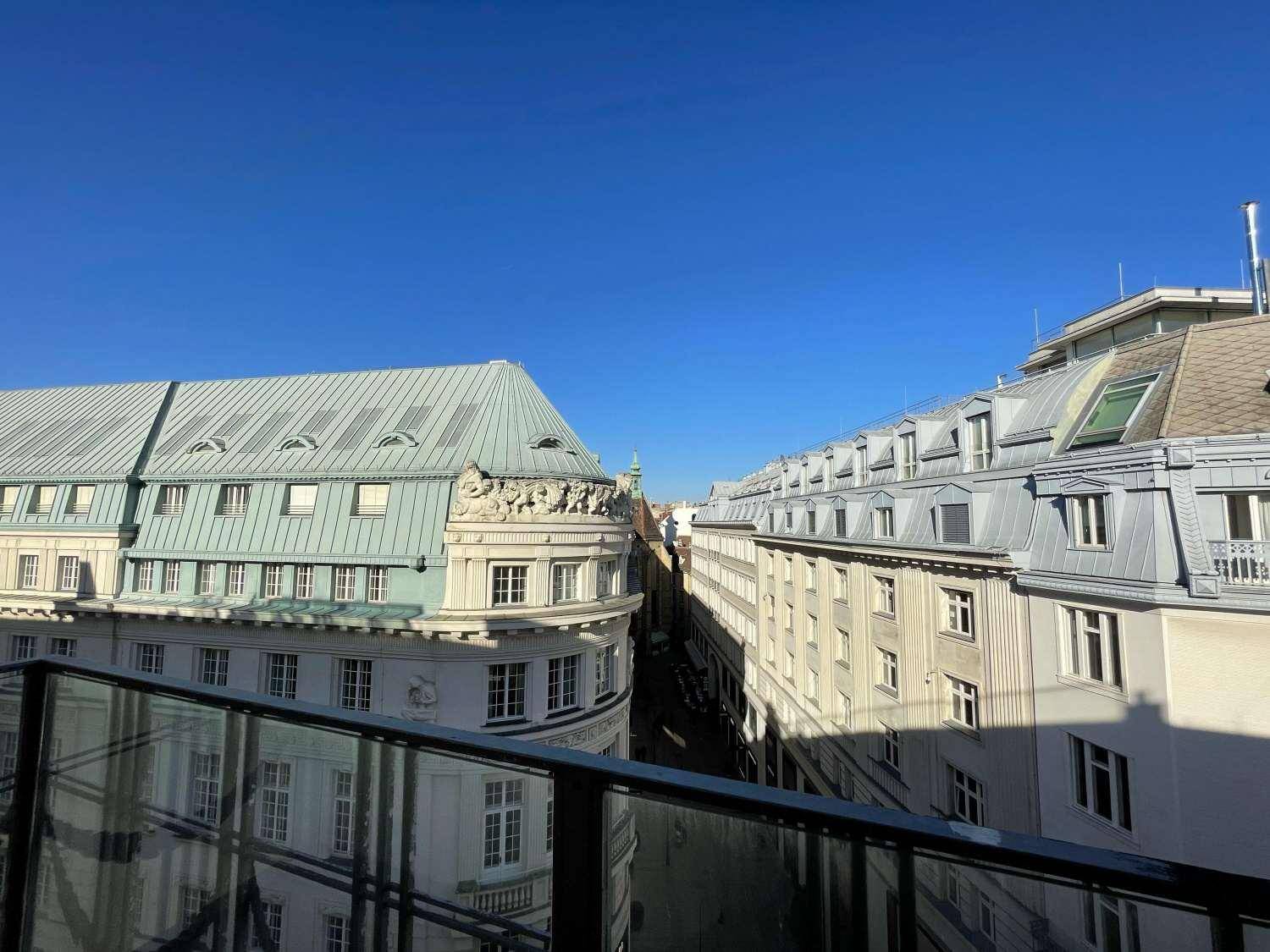 Blick von einem Balkon auf die umliegenden historischen Gebäude und eine enge Gasse der Stadt.