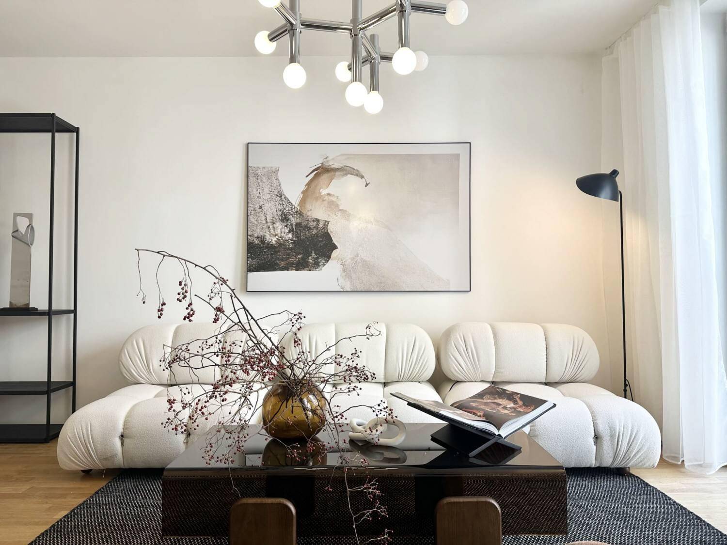 Detailansicht des Wohnzimmers mit modernem Sofa, Couchtisch und dekorativen Elementen.