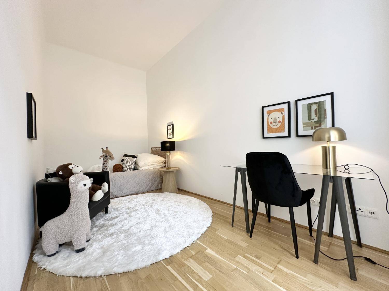 Helles Kinder- oder Gästezimmer mit Schreibtisch, Holzboden und liebevollen Details, ideal für junge Bewohner.