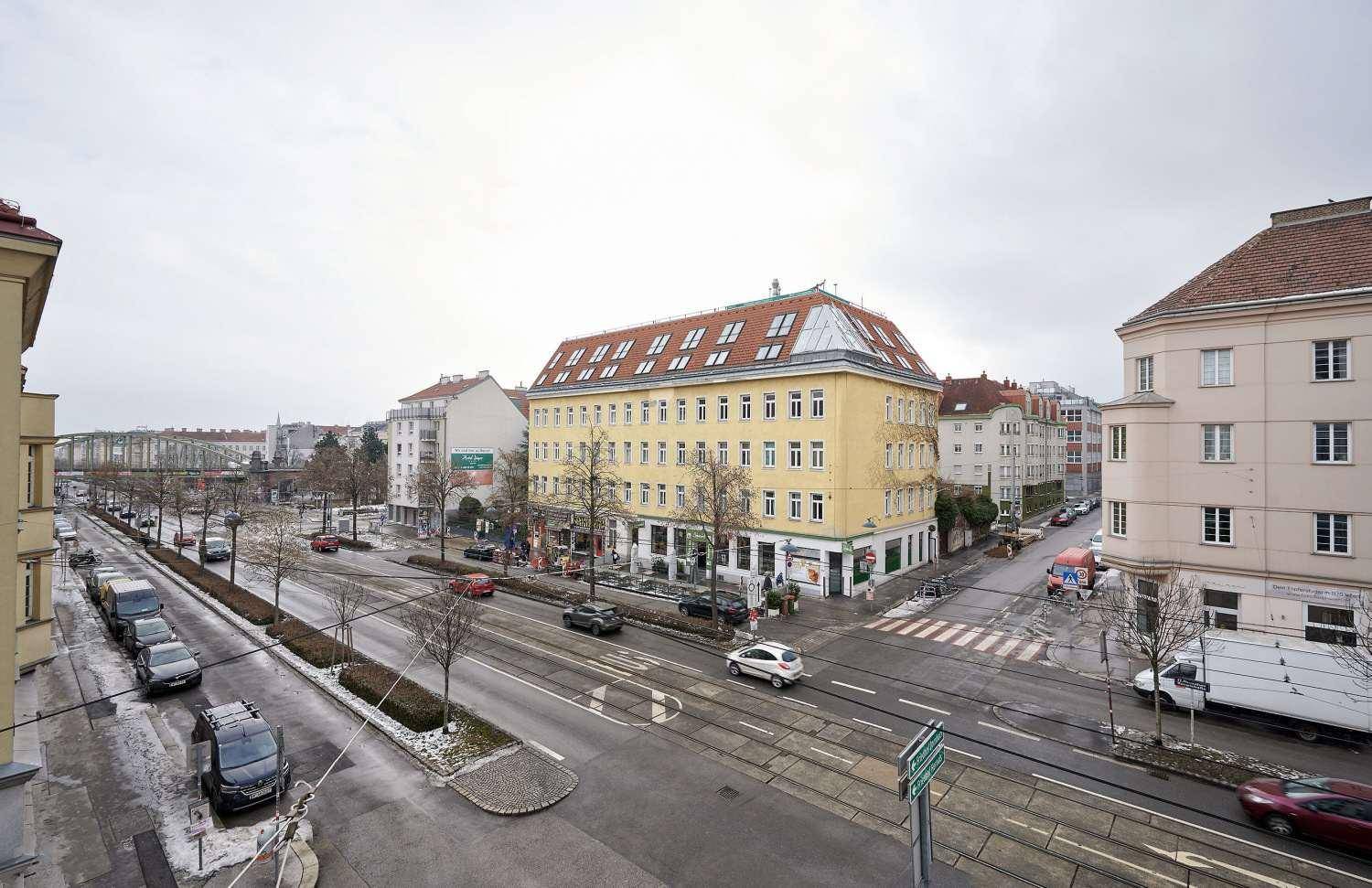 Weitläufiger Blick über eine städtische Straße mit Gebäuden und Verkehr.